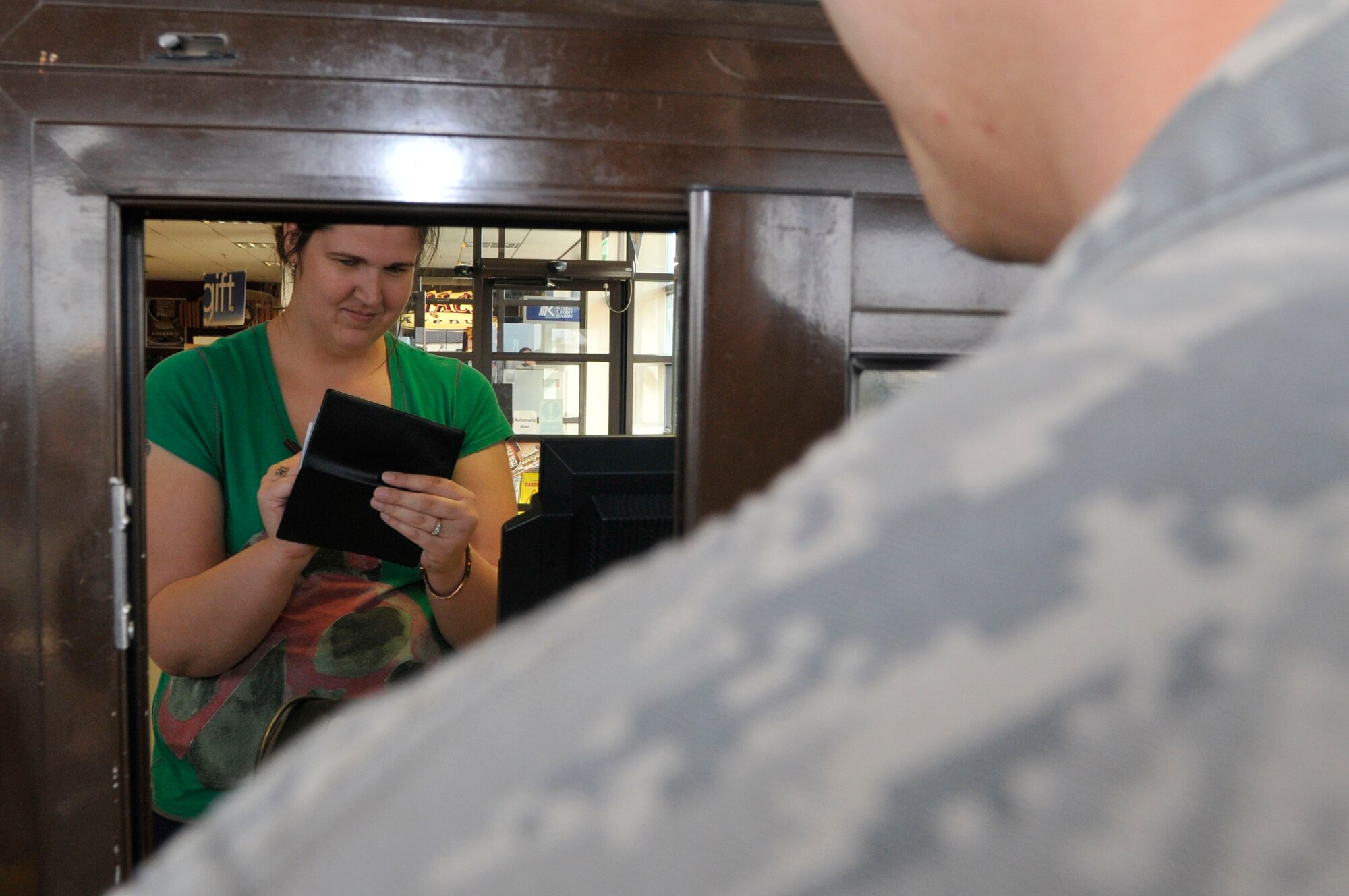 ROYAL AIR FORCE LAKENHEATH, England - Kim Parker, RAF Lakenheath Enlisted and Civilian Spouses’ Club philanthropic treasurer, writes a check for a Liberty Airman at the RAF Lakenheath gas station April 7, 2011. The RAF Lakenheath ECSC paid for Airmen's gas E-5 and below. They paid for $1000 worth of gas to help make travelling during the three-day weekend financially feasible for Liberty Airmen and their families. (U.S. Air Force photo/Senior Airman Eboni Reams)