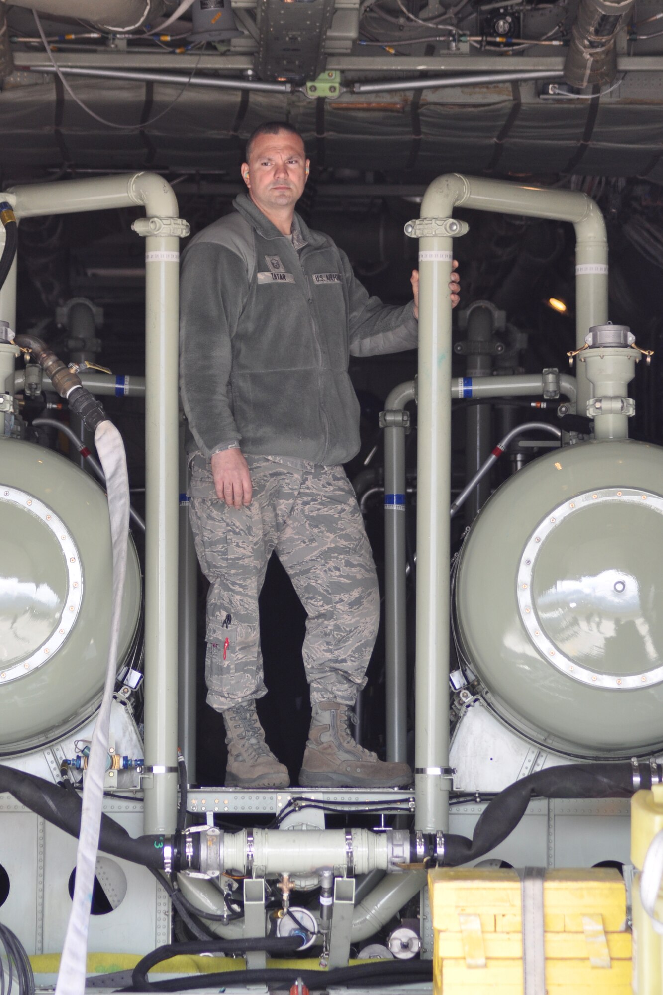 HILL AIR FORCE BASE, Utah -- Air Force Reserve Master Sgt. Paul Tatar, an aerial spray maintainer assigned to the 910th Aerial Spray Maintenance Flight, watches as a truck hauling a mixing trailer moves into position to pump an herbicide mixture into a Modular Aerial Spray System (MASS) on the cargo deck of a C-130 Hercules cargo aircraft parked on a flight line ramp here, April 1. Sergeant Tatar and a team of 910th Airlift Wing Citizen Airmen will use the MASS to apply an herbicide mixture to more than 1200 acres of target areas on the Utah Test and Training Range (UTTR). The 910th, based at Youngstown Air Reserve Station, Ohio, home to the Department of Defense's only large-area fixed wing aerial spray unit, has been tasked, through April 7, with controlling Halogeton, an evasive weed that can hamper bombing test evaluations and unexploded ordinance recovery. U.S. Air Force photo by Master Sgt. Bob Barko Jr.