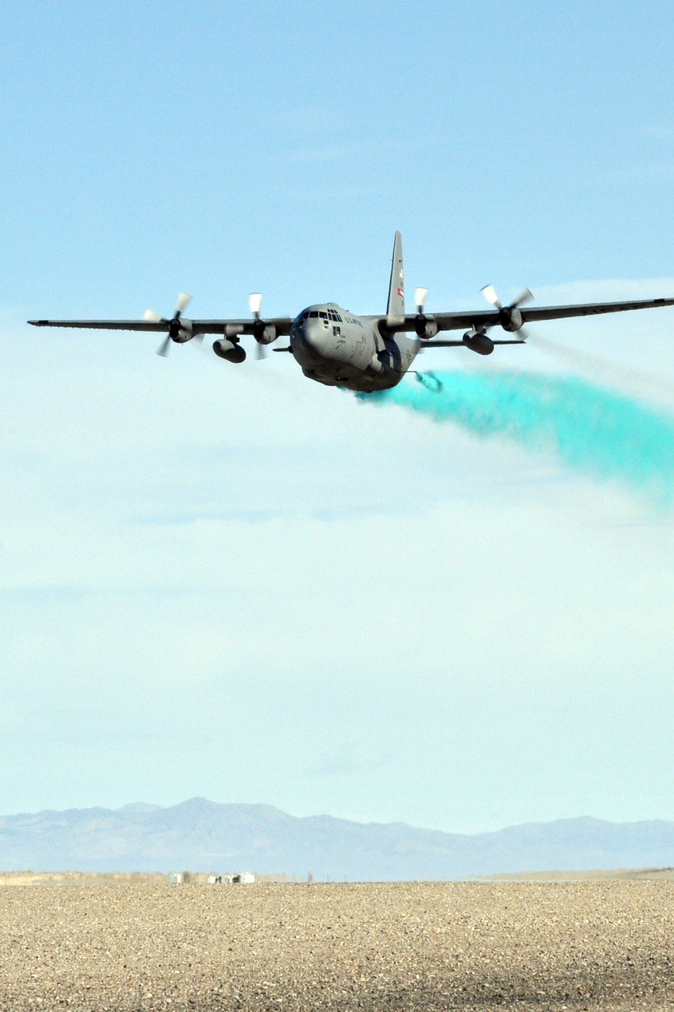 UTAH TEST AND TRAINING RANGE, Utah -- A C-130 Hercules tactical cargo transport aircraft, assigned to the Air Force Reserve's 910th Airlift Wing, applies an herbicide mixture to more 1200 acres of target areas here, March 31. The C-130 is equipped with a Modular Aerial Spray System (MASS) and the aircraft's crew is extensively trained to conduct this mission while flying at approximately 100 feet above the surface at a ground speed of 200 knots or more than 337 feet per second. The 910th, based at Youngstown Air Reserve Station, Ohio, home to the Department of Defense's only large-area fixed wing aerial spray unit, has been tasked, through April 7, with controlling Halogeton, an evasive weed that can hamper bombing test evaluations and unexploded ordinance recovery. U.S. Air Force photo by Master Sgt. Bob Barko Jr.  