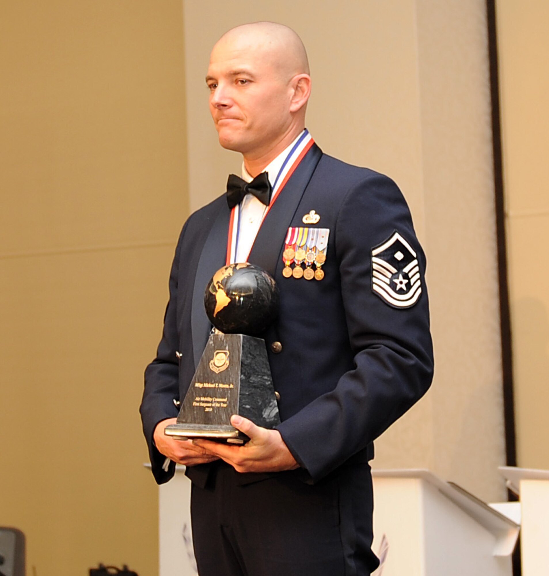Master Sgt. Michael Moore Jr., from the 92nd Security Forces Squadron at Fairchild Air Force Base, Ill., holds his award after being named the 2010 Air Mobility Command First Sergeant of the Year during AMC's Outstanding Airmen of the Year banquet April 1, 2011, at Scott AFB, Ill. (U.S. Air Force Photo/Airman 1st Class Divine Cox)
