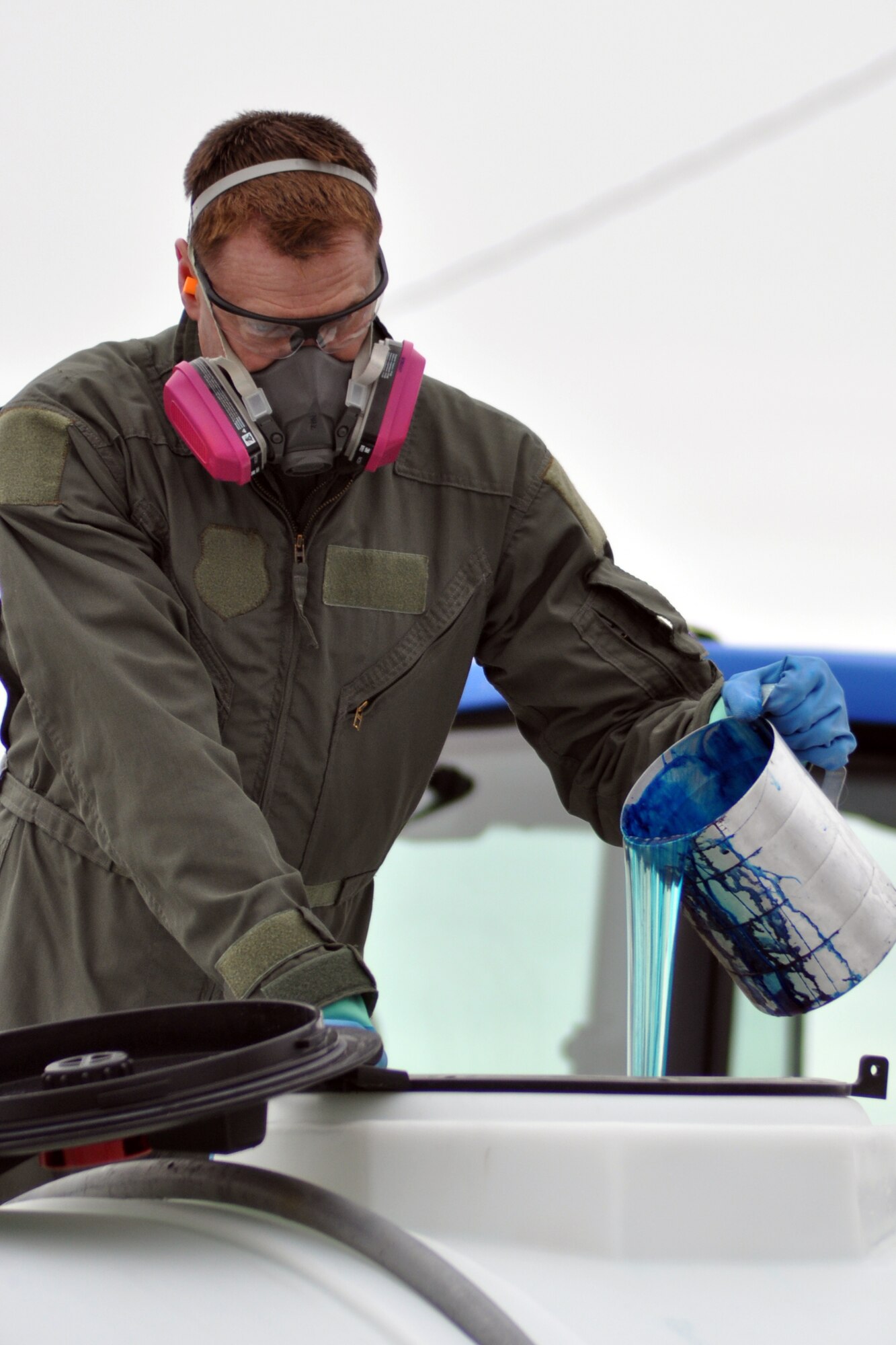 HILL AIR FORCE BASE, Utah -- Air Force Reserve Lt. Col. Mark Breidenbaugh, a research entomologist assigned to the 910th Aerial Spray Flight, pours a product called Hi-Light into a mixing tank here, March 30. The bright-blue colored product is designed to easily identify areas on the ground that have been treated with an herbicide mixture that Colonel Breidenbaugh and a team of 910th Airlift Wing Citizen Airmen are here to apply to more than 1200 acres of target areas on the Utah Test and Training Range (UTTR) from a C-130 Hercules cargo aircraft. The 910th, based at Youngstown Air Reserve Station, Ohio, home to the Department of Defense's only large-area fixed wing aerial spray unit, has been tasked, through April 7, with controlling Halogeton, an evasive weed that can hamper bombing test evaluations and unexploded ordinance recovery. U.S. Air Force photo by Master Sgt. Bob Barko Jr.