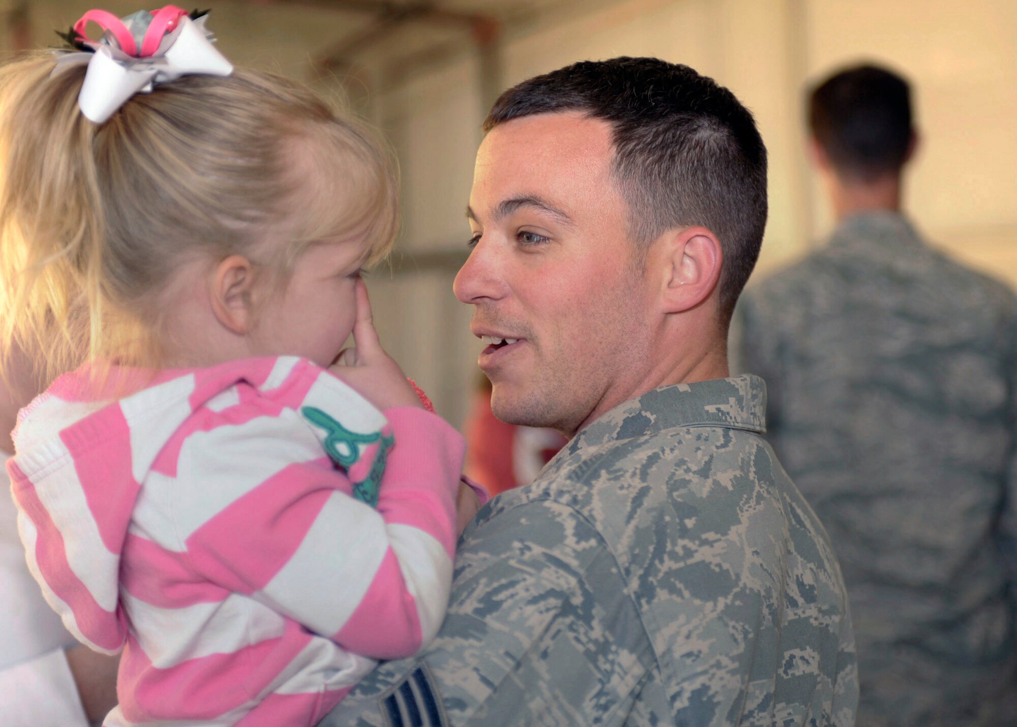 U.S. Air Force Senior Airman Jeremy McKelvain, 318th Special Operations Squadron, greets his daughter Averi at the redeployment line on Cannon Air Force Base,NM, April 6, 2011. Returning Airmen were greeted by their family and friends who arrived at the hangar ready to welcome them home. (U.S. Air Force photo by Airman Ericka Engblom)