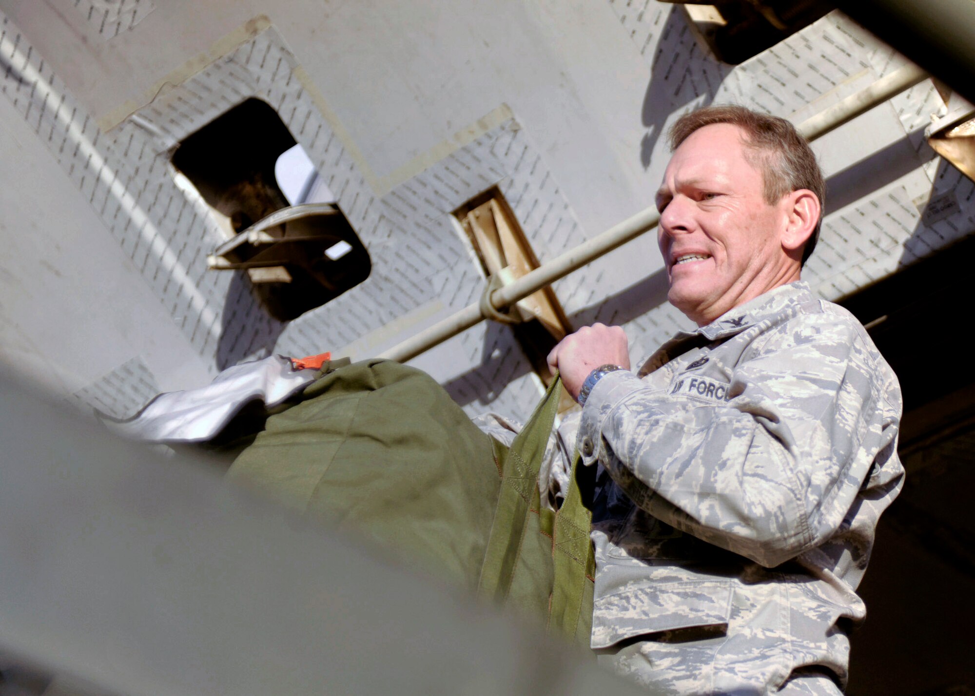 U.S. Air Force Col. Steven Kimball, 27th Special Operations Mission Support Group commander, assists returning Air Commando's in unloading their luggage upon their return from deployment April 6, 2011, on Cannon Air Force Base, NM. Friends, family and senior leadership gathered in the hangar to welcome their airmen home. (U.S. Air Force photo by Airman Ericka Engblom) 