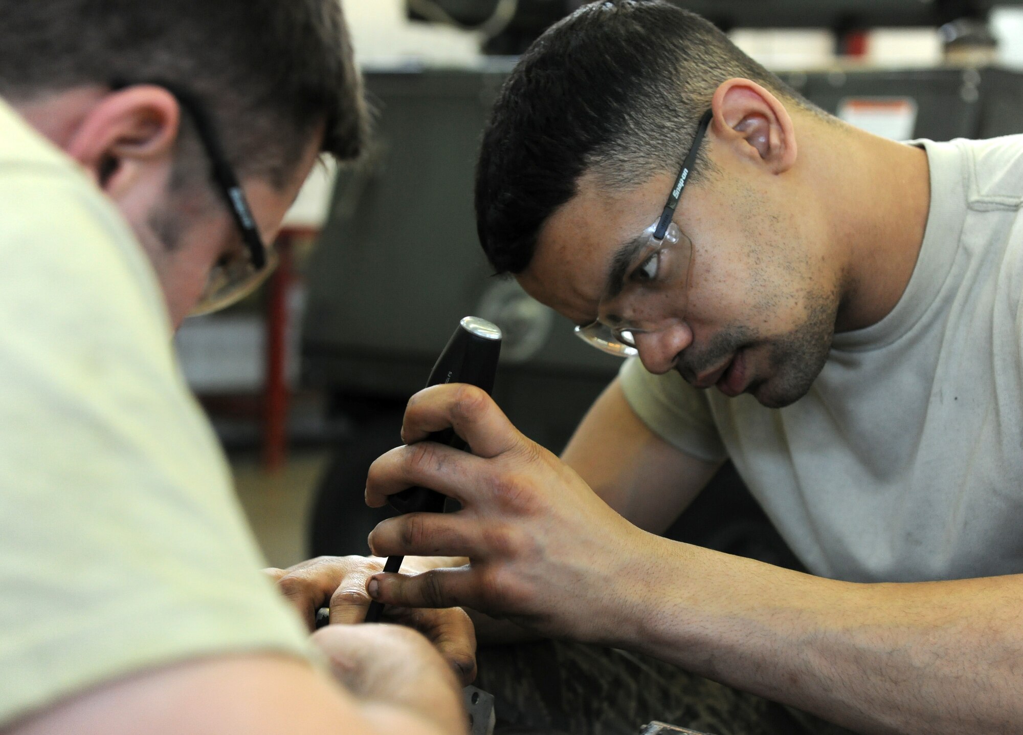 SPANGDAHLEM AIR BASE, Germany – Airman 1st Class Gary Hutchison, right, and Senior Airman Blake Skaggs, left, 52nd Equipment Maintenance Squadron aerospace ground equipment journeymen, unscrew bolts holding a directional control valve together on a MJ-1B bomb lift here April 7. The directional control valve controls the tilt and movement of the lift table enabling weapons loaders to make minuscule adjustments to munitions during the load process. The control valve has four manifolds, each controlling a specific function of the load plate. (U.S. Air Force photo/Senior Airman Nathanael Callon)