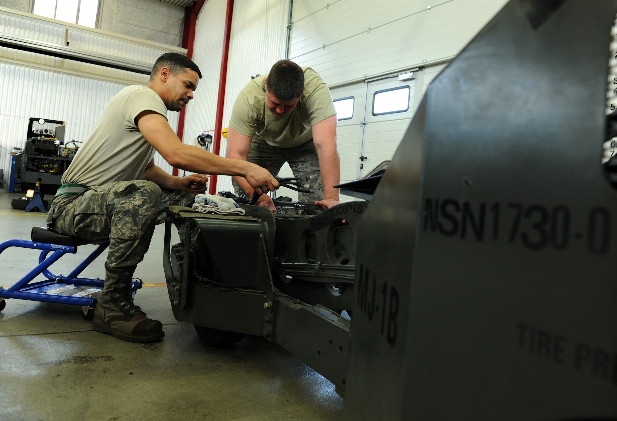 SPANGDAHLEM AIR BASE, Germany – Airman 1st Class Gary Hutchison, left, and Senior Airman Blake Skaggs, right, 52nd Equipment Maintenance Squadron aerospace ground equipment journeymen, prepare to remove a directional control valve on a MJ-1B bomb lift here April 7. The directional control valve controls the tilt and movement of the lift table enabling weapons loaders to make minuscule adjustments to munitions during the load process. (U.S. Air Force photo/Senior Airman Nathanael Callon)