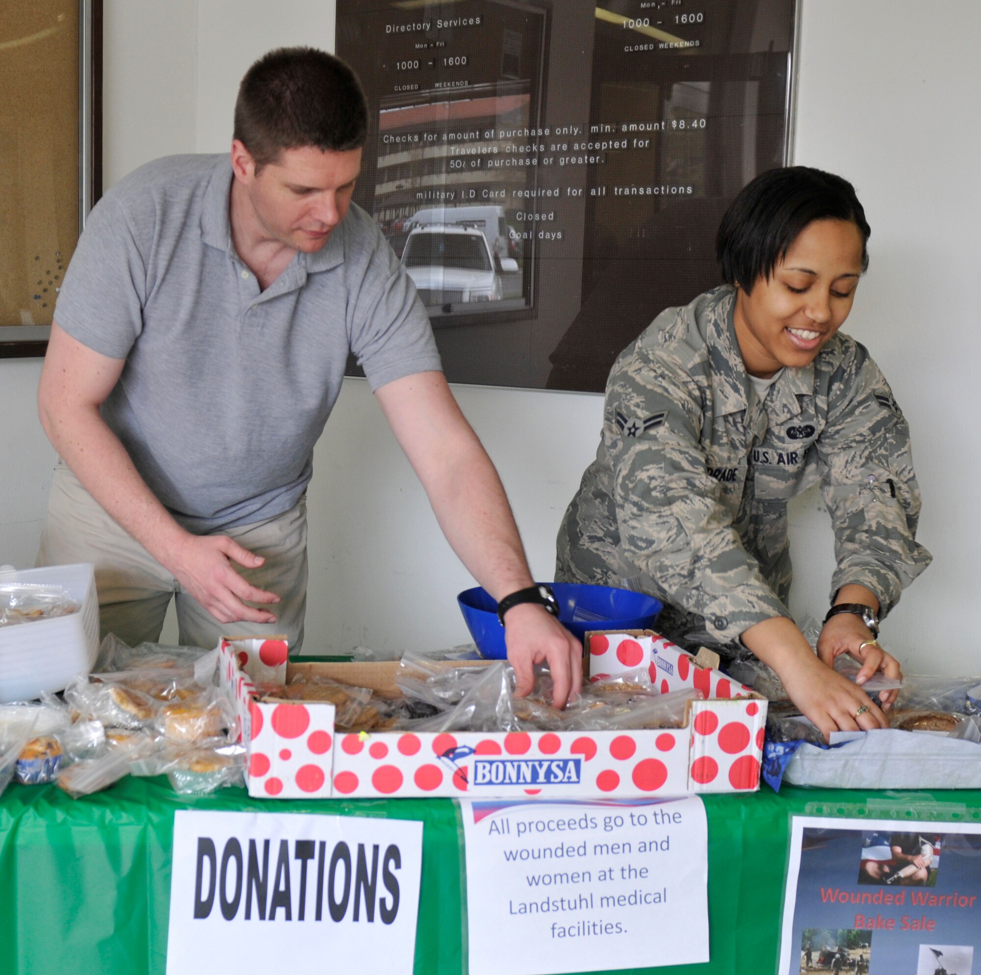 SPANGDAHLEM AIR BASE, Germany –Airman 1st Class Adande Andrade, 52nd Fighter Wing Judge Advocate general Law paralegal, and Mark Snead, spouse of Capt. Brandy Snead, chief of military justice, sort through baked goods during a bake sale at the post office here Apr 4. All proceeds go to the wounded and ill service members at Landstuhl Regional Medical Center. They are sent there to receive care and recover from their injuries after being evacuated from overseas contingency operations. (U.S. Air Force photo/Airman 1st Class Brittney Frees)