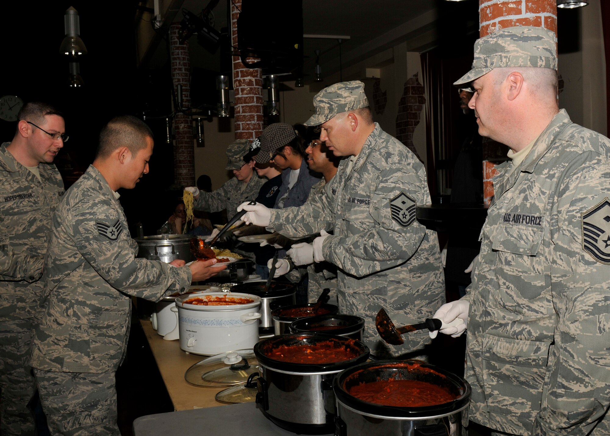SPANGDAHLEM AIR BASE, Germany—Spangdahlem Airmen serve spaghetti during a luncheon at the Brick House here March 25. The luncheon was hosted to raise money for the wounded service members. All proceeds go to the wounded men and women at the Landstuhl Regional Medical Center. The program provides personalized services to combat wounded, ill and injured Airmen and their families. (U.S. photo/Airman 1st Class Brittney Frees)