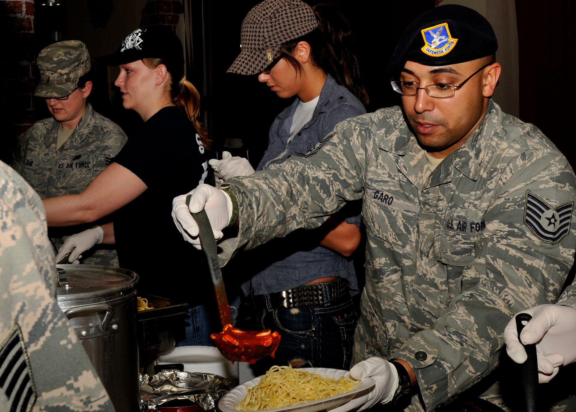 SPANGDAHLEM AIR BASE, Germany—Spangdahlem Airmen serve spaghetti during a luncheon at the Brick House here March 25. The luncheon was hosted to raise money for the wounded service members. All proceeds go to the wounded men and women at the Landstuhl Regional Medical Center. The program provides personalized services to combat wounded, ill and injured Airmen and their families. (U.S. photo/Airman 1st Class Brittney Frees)