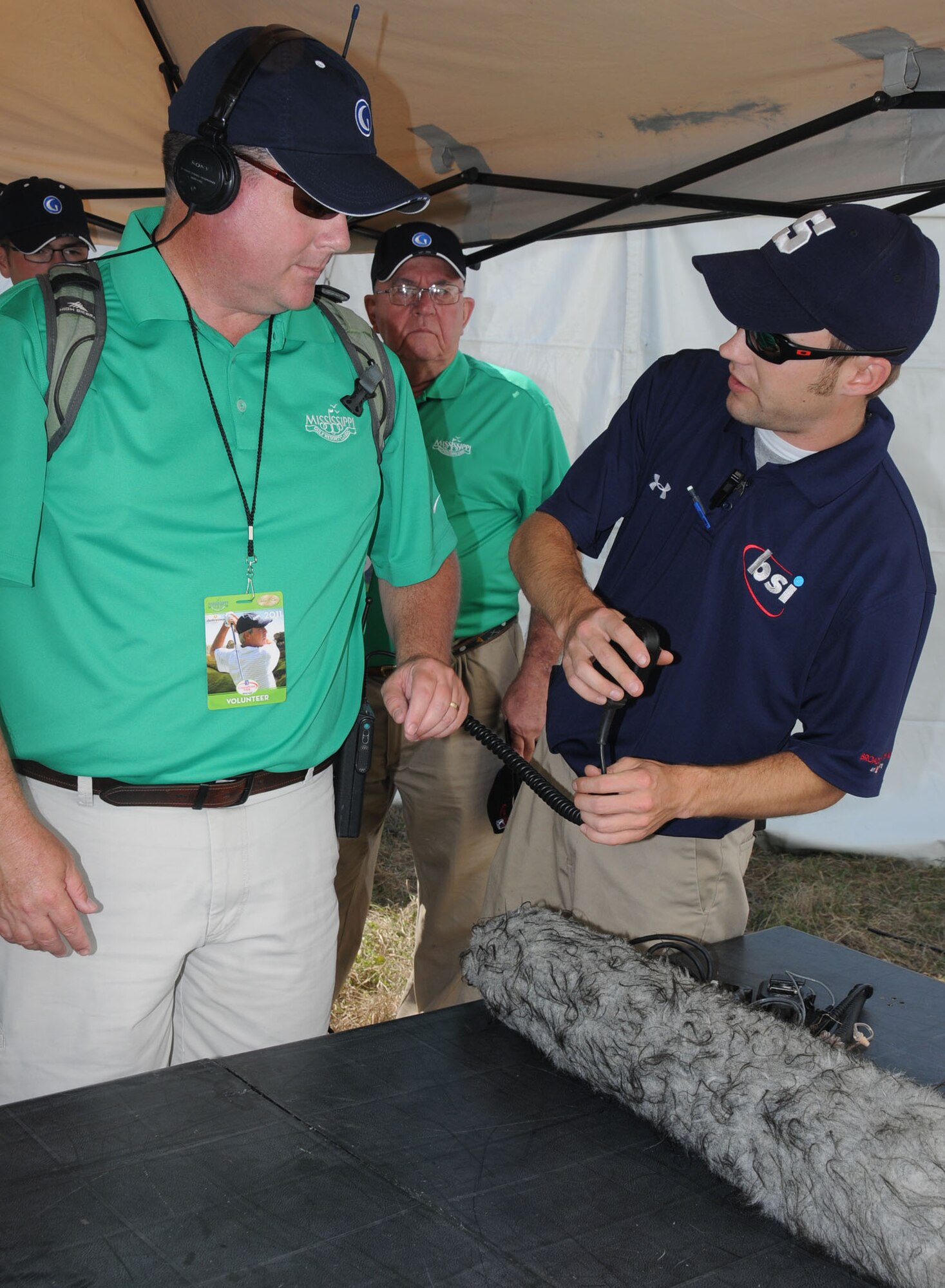 Ken Oates, left, 81st Training Wing, gets suited up with a parabolic microphone from
Eric Pfeiffer, Broadcast Sports Inc., before Friday’s opening round.  Oates volunteered as a microphone operator.  The Golf Channel did several nationwide broadcasts during last weekend’s tournament at Fallen Oak Golf Club in Saucier.  (U.S. Air Force photo by Kemberly Groue)