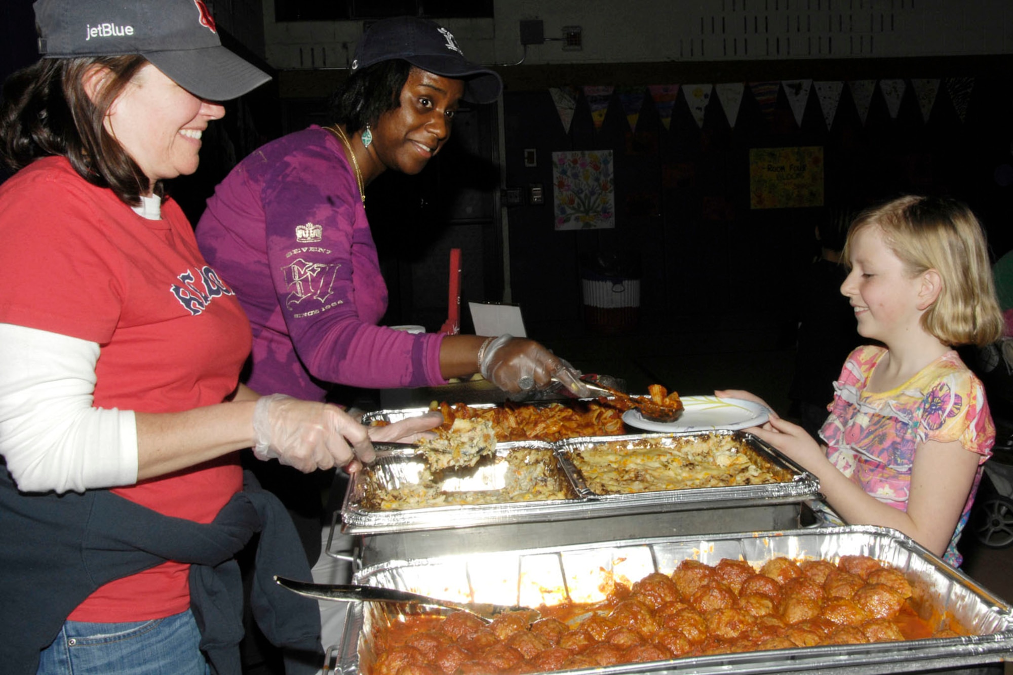 HANSCOM AIR FORCE BASE, Mass. - Laurel Wironen (left) and Coletha Cox (middle) serve pasta to Lauren Decker during Family Pasta Night at the Youth Center on March 31. All Hanscom families were invited to the special meal to help kick off Month of the Military Child. (U.S. Air Force photo by Linda LaBonte Britt)