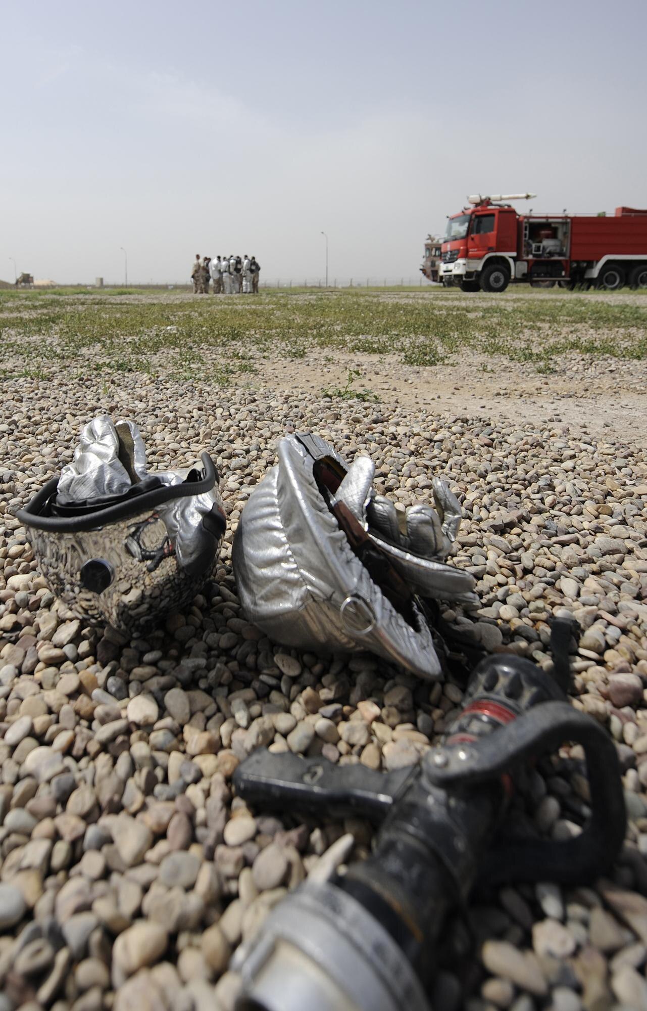 Iraqi air force and U.S. contractor firefighters huddle for debrief after wrapping up a joint C-130 crash simulation exercise, April 3. Kirkuk's Air Force base transition team spearheaded the exercise with a dozen American and Iraqi firefighters to improve communication and joint tactics between the two fire departments. (U.S. Air Force/Tech. Sgt. Jason Lake)




