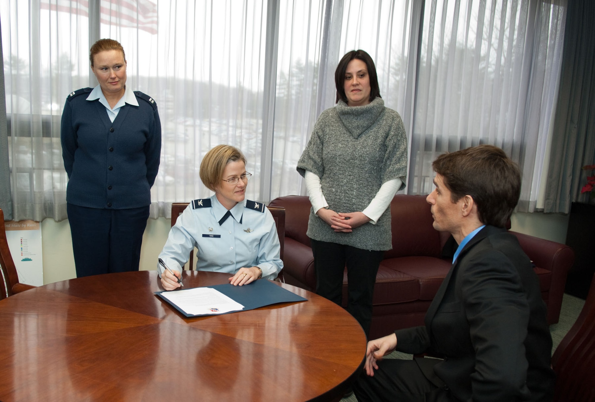 HANSCOM AIR FORCE BASE, Mass. - Matt Nicoli (right), Family Advocacy Program, explains to Col. Stacy L. Yike, 66th Air Base Group commander, some of the programs that will be presented by FAP throughout April for Child Abuse Prevention and Awareness Month, as Capt. Lisa Hoyt (left) and  Erin Hennessy look on. Colonel Yike signed a proclamation on April 4 declaring April as Child Abuse Prevention and Awareness Month on base. (U.S. Air Force photo by Rick Berry)