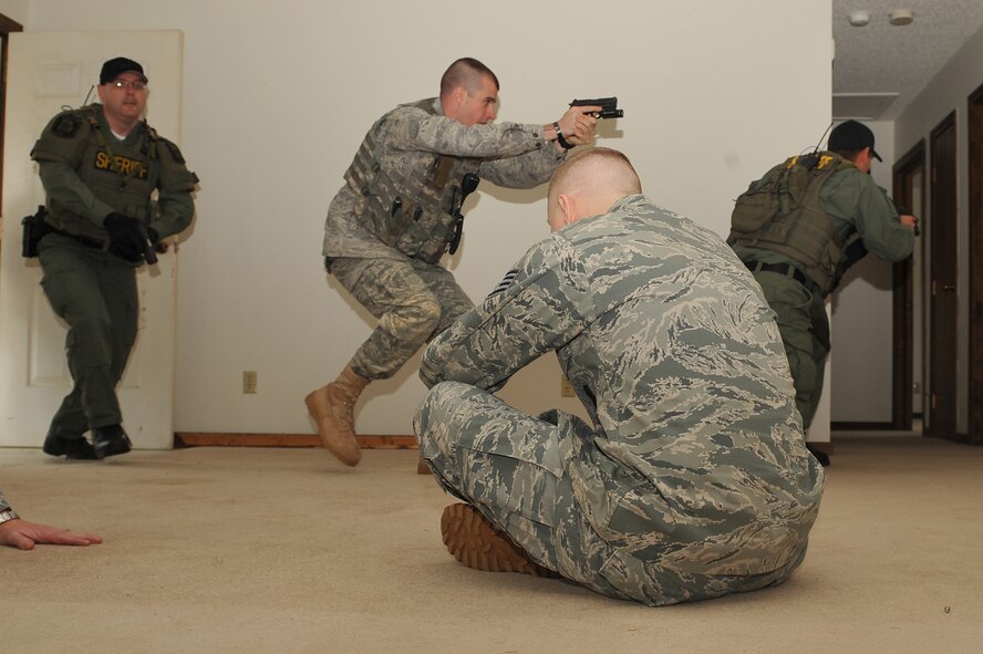 SEYMOUR JOHNSON AIR FORCE BASE, N.C. -- The 4th Security Forces Squadron and the Duplin County Sheriff's Office special response team members practice securing a building at Seymour Johnson Air Force Base, N.C., April 5, 2011. Staff Sgt. Tommy Dailey sits in the middle of the room playing a scared assailant. Sergeant Dailey is a 4th SFS Combat Arms Training and Maintenance instructor and is from Desoto, Ill. (U.S. Air Force photo/Senior Airman Whitney Lambert) 