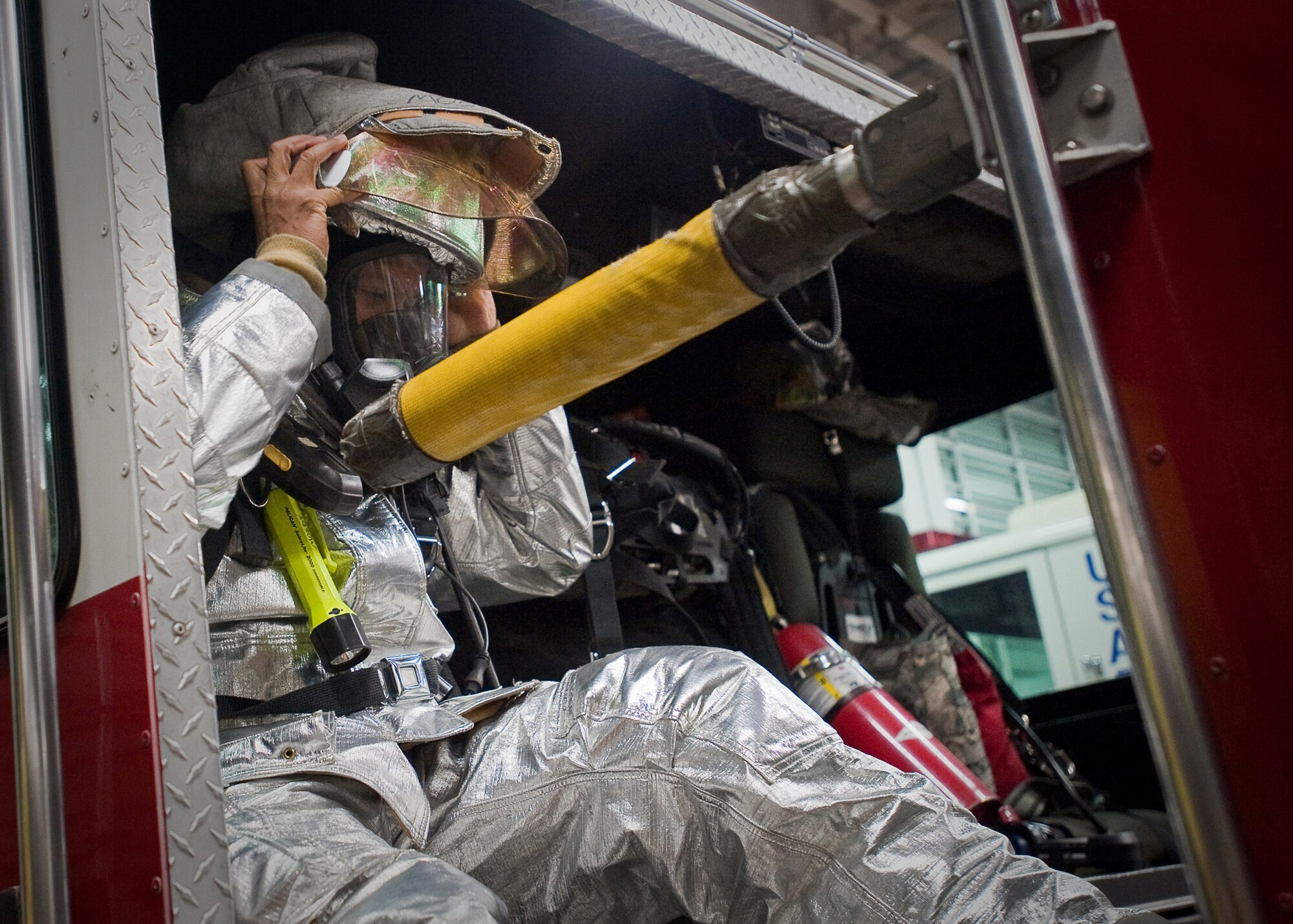 YOKOTA AIR BASE, Japan -- Airman 1st Class Darryl Mosby, 374th Civil Engineer Squadron firefighter, adjust his gas mask on the back of a fire truck here April 7, 2011. The Fayetteville, N.C., native is stationed in Japan and is currently supporting Operation Tomodachi. U.S. forces remain focused to help support the Japanese during relief efforts. (U.S. Air Force photo/Airman 1st Class Andrea Salazar)