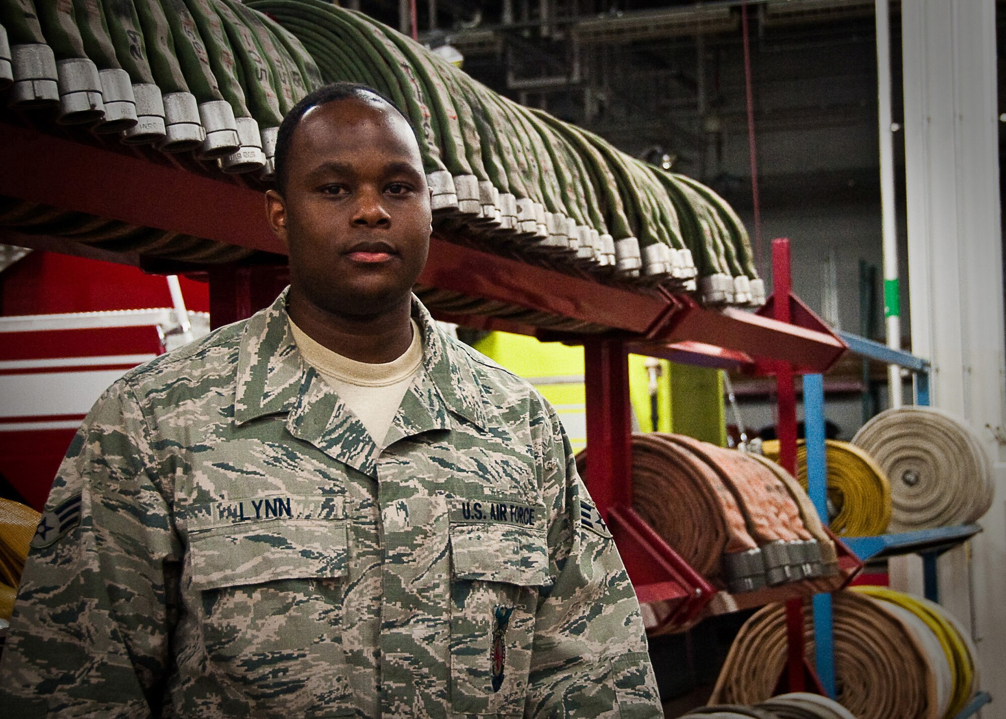 YOKOTA AIR BASE, Japan -- Senior Airman Stanley Lynn, 374th Civil Engineer Squadron firefighter, stands in front of fire hoses here April 7, 2011. The Jackson, Miss., native is stationed in Japan and is currently supporting Operation Tomodachi. (U.S. Air Force photo/Airman 1st Class Andrea Salazar)
