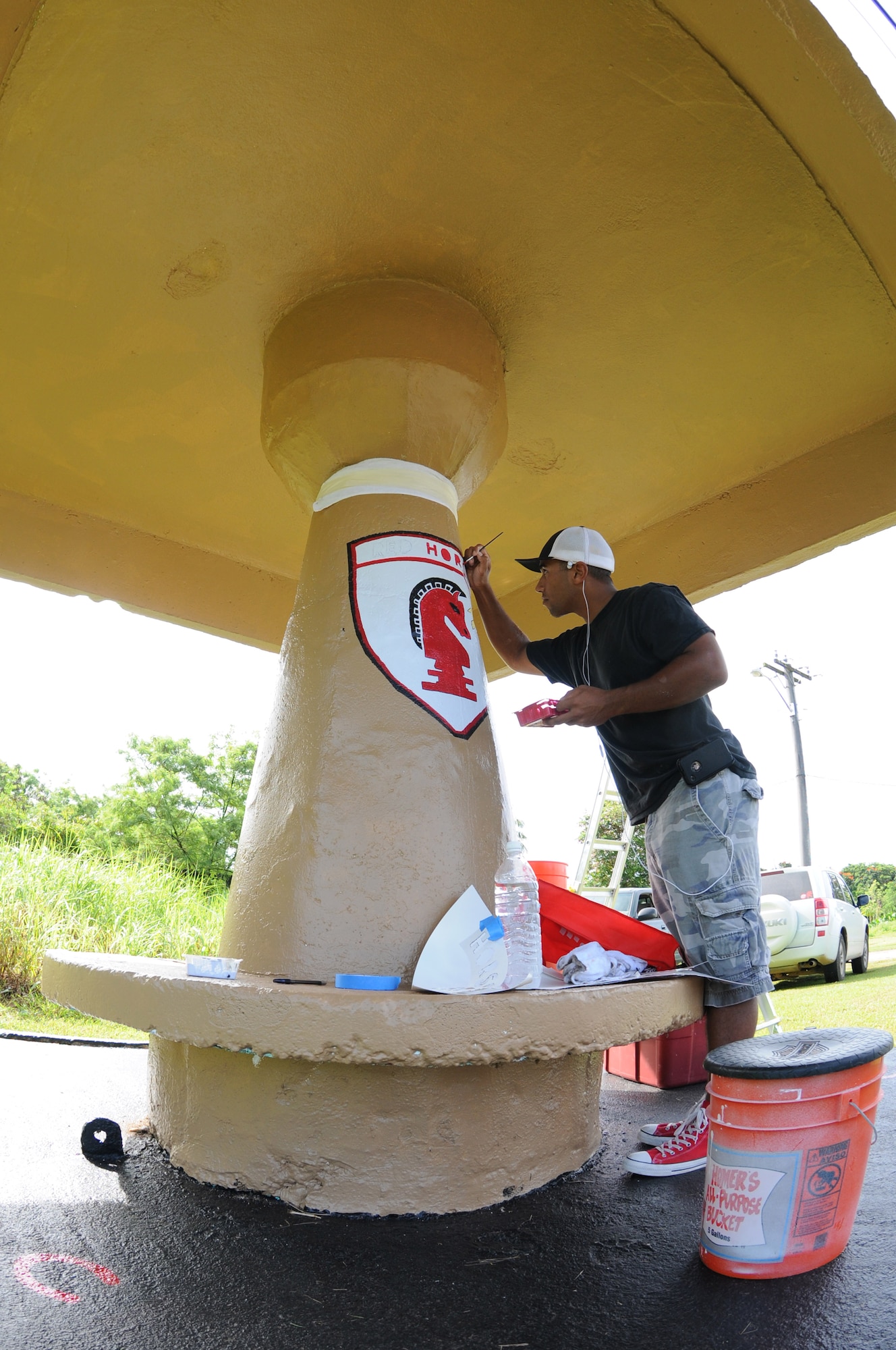 ANDERSEN AIR FORCE BASE, Guam - Staff Sgt. Cameron Pleasant, 554th RED
HORSE Squadron structures shop, works on the RED HORSE emblem on the bus
stop the squadron has adopted within the local community, April 7. Members
of the squadron have volunteered more than 100 hours to ensure the stop
looks perfect for the local school children. (U.S. Air Force photo / Senior
Airman Carlin Leslie)
