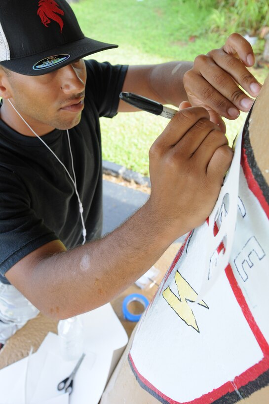 ANDERSEN AIR FORCE BASE, Guam - Staff Sgt. Cameron Pleasant, 554th REDHORSE Squadron structures shop, outlines a stencil saying "RED HORSE" on thebus stop they adopted in Yigo, Guam, April 7. Through community relations,groups and units here may adopt a local bus stop to paint with their owndesigns and help clean up the local community. (U.S. Air Force photo /Senior Airman Carlin Leslie)