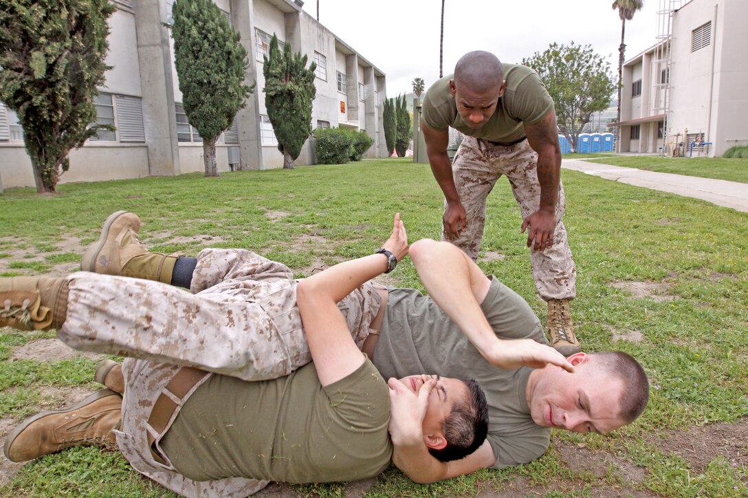 Corporal Jerrell E. Chance, a black belt martial arts instructor with Headquarters and Support Battalion, Marine Corps Base Camp Pendleton supervises one of his students execute a face rip from the guard, during one of his black belt courses, April 7.