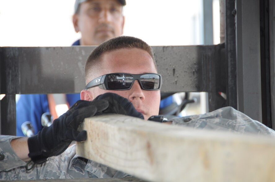 U.S. Air Force Senior Airman Michael Cagle, 60th Medical Group biomedical equipment repair technician, loads wooden stakes on a truck delivering 21 pallets of medical supplies to Cumuto Barracks in Trinidad and Tobago April 8, 2011. Cagle is a part of the Expeditionary Medical Support Health Response Team in support of the Allied Forces Humanitarian Exercise/Fuerzas Aliadas or FA HUM 2011. (U.S. Air Force photo by 2d Lt Joel Banjo-Johnson/Released)