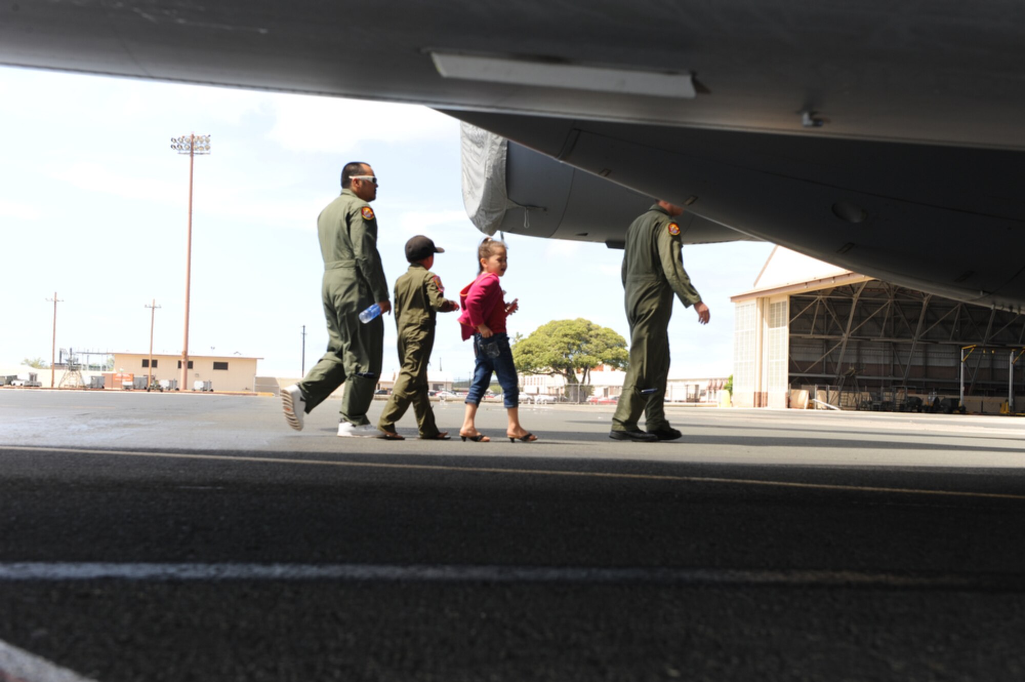 Jonah Kalaikai Sr., and his two children seven year-old Jonah "J-Boy" and six year-old Kayla walk with 535th Airlift Squadron pilot Captain Domonic Bonello as he gives them a tour from the outside of a C-17 Globemaster III while at the Joint Base Pearl Harbor-Hickam, Hawaii on April 2, 2010. J-Boy was invited to JBPHH to participate in the "Pilot for a Day" program which is a partnership between Kapi'olani Medical Center and the 15th Airlift Wing that gives a special day to a child that is dealing with a serious or chronic condition. J-Boy was diagnosed with Acute Myeloid Leukemia at age two and has been in and out of remission five times since then. (U.S. Air Force photo/Tech Sgt. Cohen A. Young)