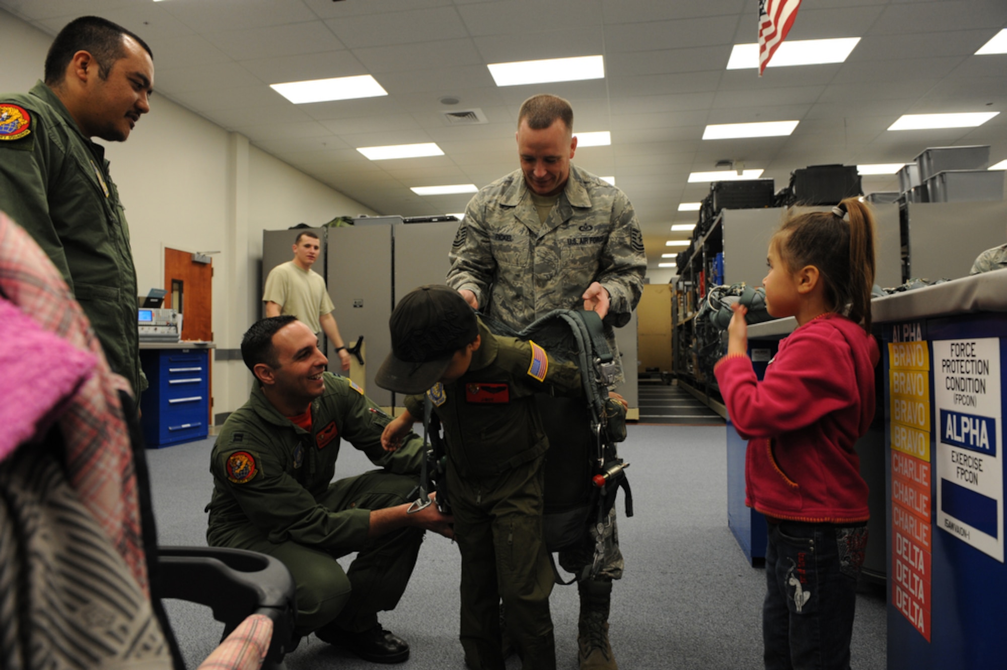 Seven year-old Jonah "J-Boy" Kalaikai puts on a flight harness with the help of Captain Dominc Bonello (left) and Technical Sergeant Bobby Pickel while at the 535th Airlift Squadron, Joint Base Pearl Harbor-Hickam, Hawaii on April 2, 2010. Jonah was invited to JBPHH to participate in the "Pilot for a Day" program which is a partnership between Kapi'olani Medical Center and the 15th Airlift Wing that gives a special day to a child that is dealing with a serious or chronic condition. Jonah was diagnosed with Acute Myeloid Leukemia at age two and has been in and out of remission five times since then. (U.S. Air Force photo/Tech Sgt. Cohen A. Young)