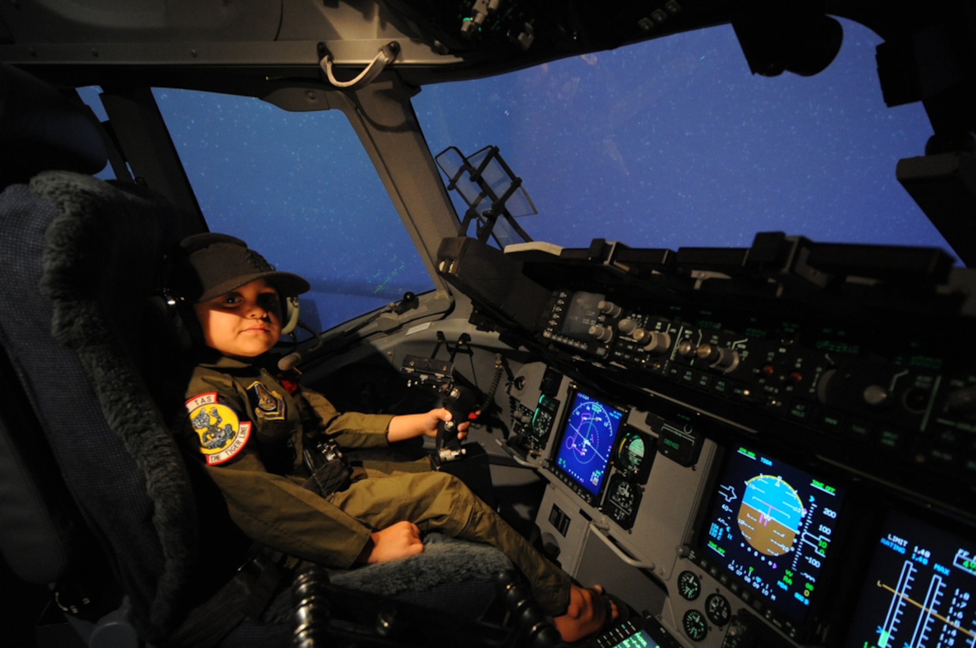 Seven year-old Jonah Kalaikai posses for a photo while sitting inside a C-17 Globemaster III simulator under snowy conditions while at the 535th Airlift Squadron, Joint Base Pearl Harbor-Hickam, Hawaii on April 2, 2010. Jonah was invited to JBPHH to participate in the "Pilot for a Day" program which is a partnership between Kapi'olani Medical Center and the 15th Airlift Wing that gives a special day to a child that is dealing with a serious or chronic condition. Jonah was diagnosed with Acute Myeloid Leukemia at age two and has been in and out of remission five times since then. (U.S. Air Force photo/Tech Sgt. Cohen A. Young)