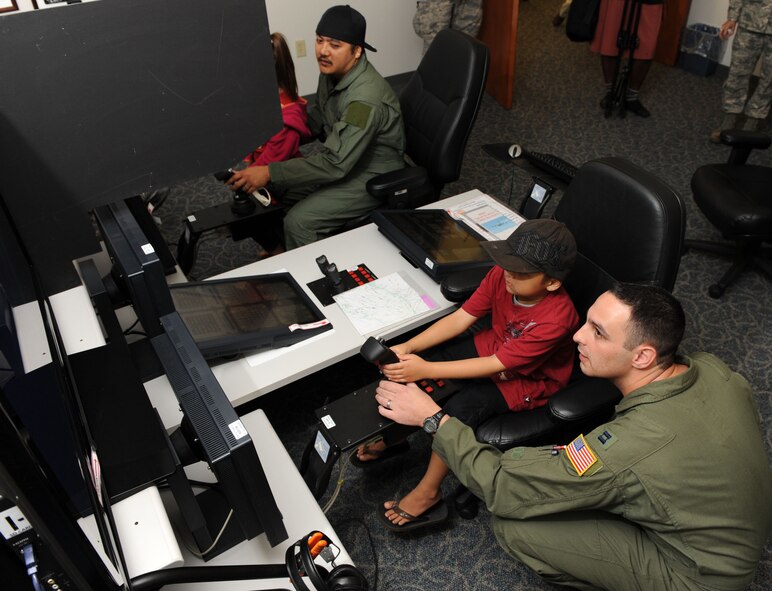 Seven year-old Jonah Kalaikai receives a little flight training from Captain Domonic Bonello of the 535th Airlift Squadron, Joint Base Pearl Harbor-Hickam, Hawaii on April 2, 2010. Jonah was invited to JBPHH to participate in the "Pilot for a Day" program as part of a partnership between Kapi'olani Medical Center and the 15th Airlift Wing to give a special day to a child that is dealing with a serious or chronic condition. Jonah was diagnosed with Acute Myeloid Leukemia at age two and has been in and out of remission five times since then. (U.S. Air Force photo/Tech Sgt. Cohen A. Young)