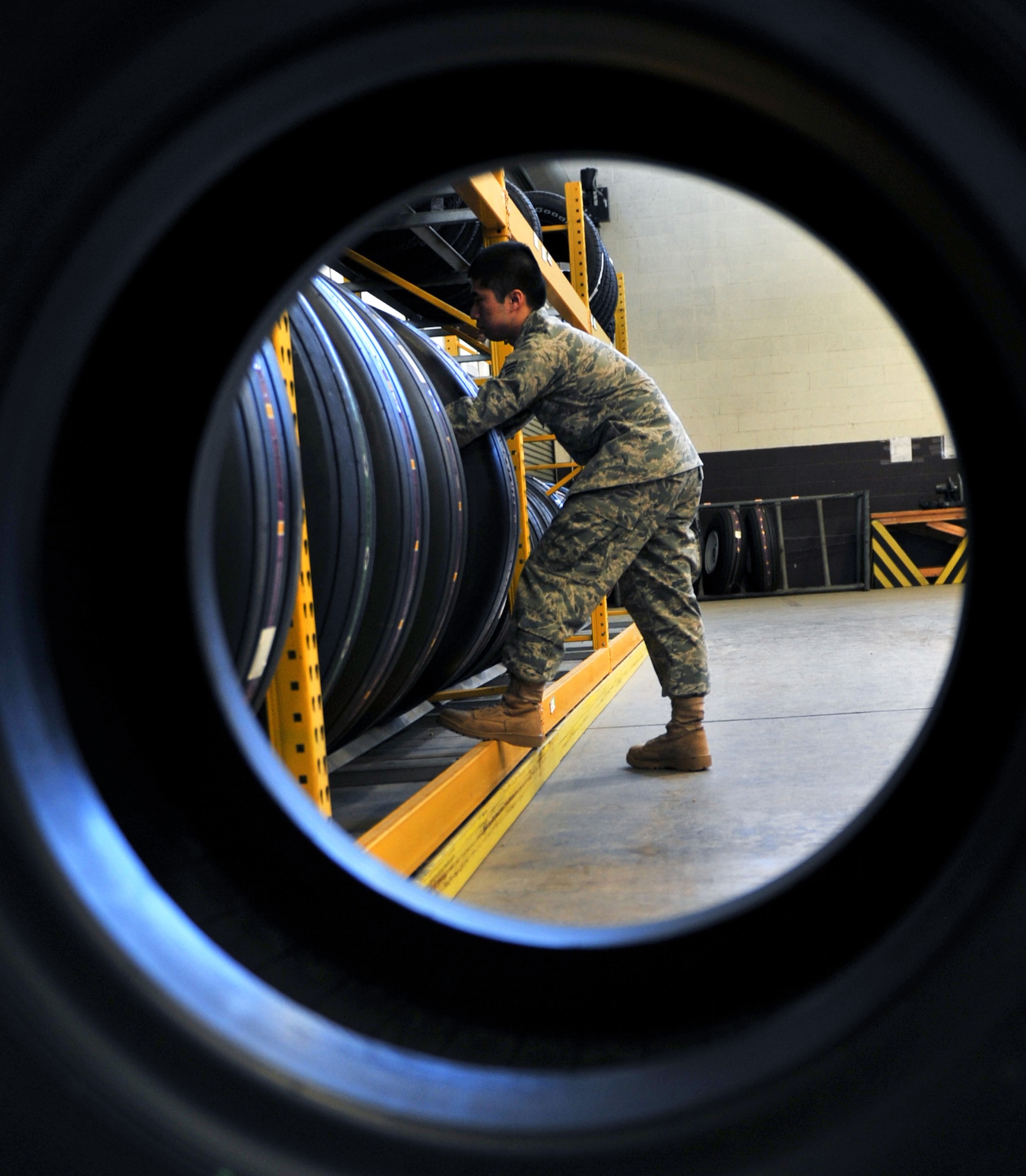 Senior Airman Jih Shang Seto, a 19th Logistics Readiness Squadron storage and issue apprentice, removes a C-130 tire from pick-up and delivery line April 5, 2011, at Little Rock Air Force Base, Ark. Central storage personnel receive 300 orders a day keeping the largest C-130 fleet in the world operational. (U.S. Air Force photo by Airman 1st Class Rusty Frank)
