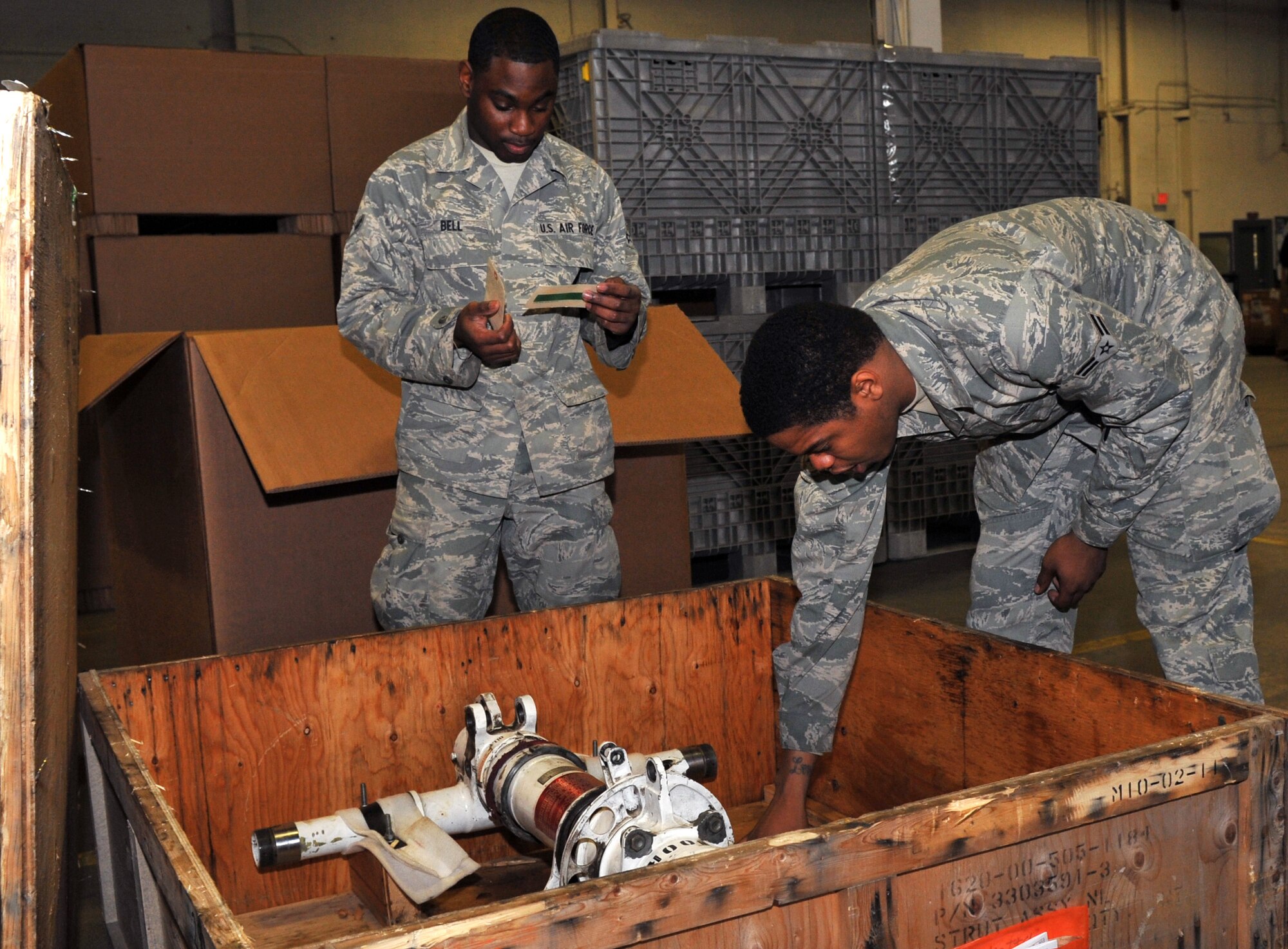 Airman Dvonte Bell, a 19th Logistics Readiness Squadron flight services technician, and Airman 1st Class Jerome Marsh Jr., a 19th Logistics Readiness Squadron flight services journeyman, inspect a C-130 strut.  The flight service center’s responsibility is to ensure parts are scanned, inspected and shipped to the right place for maintenance. (U.S. Air Force photo by Airman 1st Class Rusty Frank)