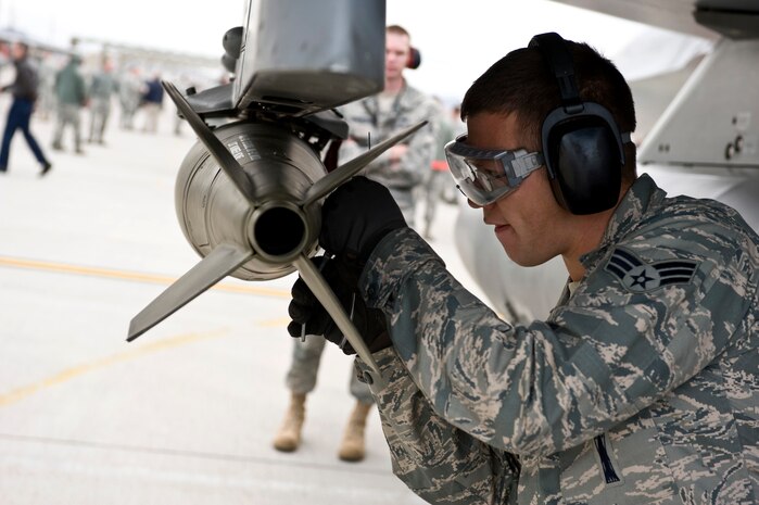 NELLIS AIR FORCE BASE, Nev.-- Senior Airman Lucas Wolf, 57th Aircraft Maintenance Squadron, load crew member, loads a Mark-82 bomb onto an F-16 during the 1st quarterly weapons load competition April 8. Weapons load competitions are conducted quarterly to keep Airmen sharp and recognize superior performers. Weapons load teams are evaluated for their use of the checklist, safety, and overall speed. (U.S. Air Force photo by Airman 1st Class Matthew Lancaster)