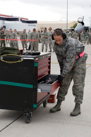NELLIS AIR FORCE BASE, Nev.-- Airman 1st Class Amanda Schreckengost, 57th Aircraft Maintenance Squadron, load crew member prepares to grab a tool during the 1st quarterly weapons load competition April 8. Weapons load competitions are conducted quarterly to keep Airmen sharp and recognize superior performers. Weapons load teams are evaluated for their use of the checklist, safety, and overall speed. (U.S. Air Force photo by Airman 1st Class Matthew Lancaster)