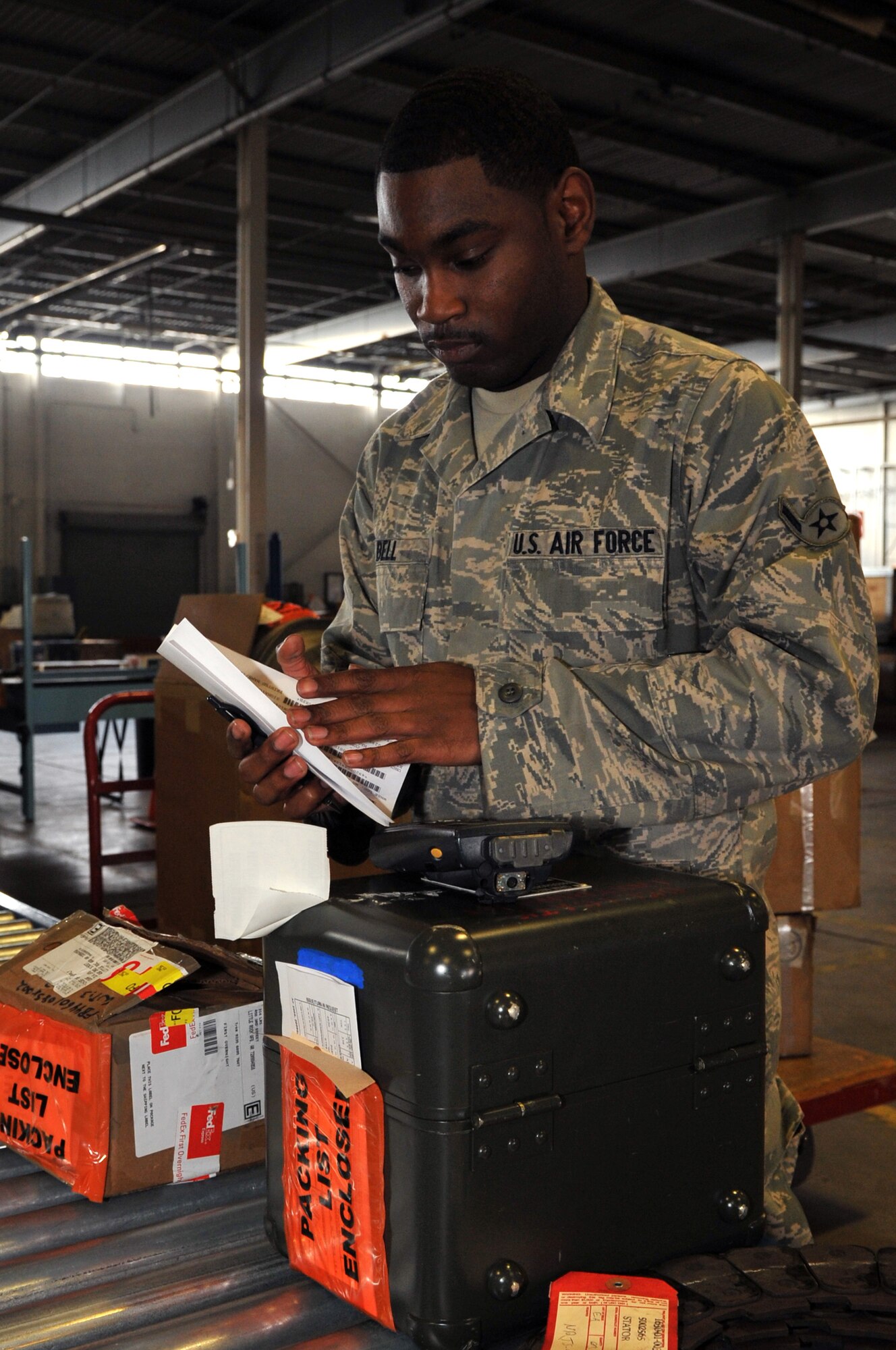 Airman Dvonte Bell, a 19th Logistics Readiness Squadron flight services technician, removes paperwork to be scanned March 31, 2011, at Little Rock Air Force Base, Ark. The flight service center’s responsibility is to ensure parts are scanned, inspected and shipped to the right place for maintenance. (U.S. Air Force photo by Airman 1st Class Rusty Frank)
