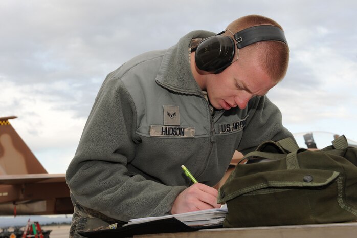 NELLIS AIR FORCE BASE, Nev. -- Airman 1st Class Michael Hudson, 757th Aircraft Maintenance Squadron weapons load crew member, documents aircraft forms after completing a weapons load during the quarterly load crew competition here April 8.  Weapons load competitions are conducted quarterly to keep Airmen sharp and recognize superior performers. Weapons load teams are evaluated for use of the checklist, safety, and overall speed. (U.S Air Force photo by Staff Sgt. Taylor Worley)