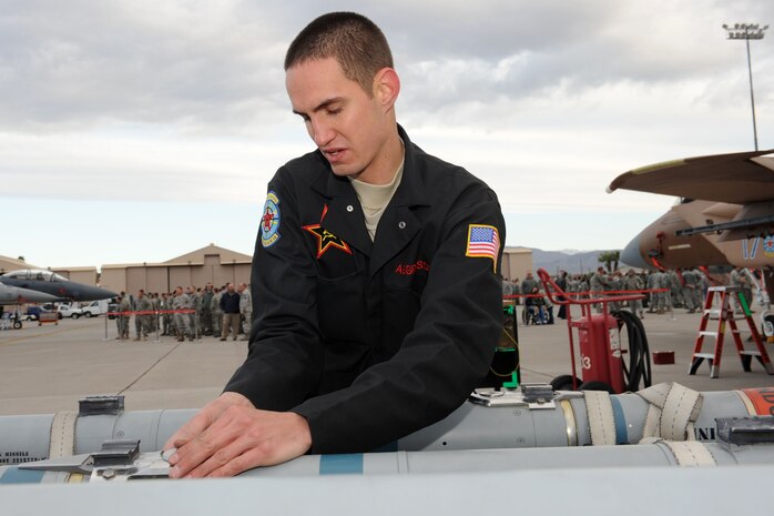 NELLIS AIR FORCE BASE, Nev. -- Senior Airman Richard Maher, 757th Aircraft Maintenance Squadron weapons load crew member, performs munitions preparations during the quarterly load crew competition here April 8.  Weapons load competitions are conducted quarterly to keep Airmen sharp and recognize superior performers. Weapons load teams are evaluated for use of the checklist, safety, and overall speed. (U.S Air Force photo by Staff Sgt. Taylor Worley)