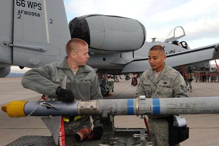 NELLIS AIR FORCE BASE, Nev. -- Airman 1st Class Michael Hudson, a weapons load crew member, and Staff Sgt. Chris Manansala, a weapons load crew team chief, with the 757 Aircraft Maintenance Squadron, perform munitions preparation during the quarterly load crew competition here April 8.  Weapons load competitions are conducted quarterly to keep Airmen sharp and recognize superior performers. Weapons load teams are evaluated for use of the checklist, safety, and overall speed. (U.S Air Force photo by Staff Sgt. Taylor Worley)
