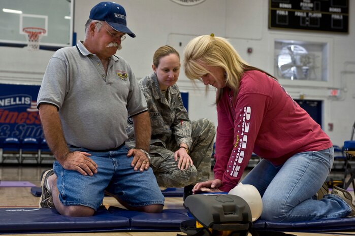 NELLIS AIR FORCE BASE, Nev.-- Rich Johnson, gun club manager, and Jane Weber, gun club clerk, 99th Force Support Squadron, participates in the Automated External Defibrillator Rodeo while Master Sgt. Angela Lejeune, 99th Medical Support Squadron, non-commissioned officer in charge of pharmaceutics services, aides in their training April 7. The rodeo is a 30 min. class held at the Nellis fitness center, that teaches participants how to use an AED. The Public Access Defibrillation program set up the AED rodeo so service members and civilians working on base become more aware of the equipments potential to save lives. (U.S. Air Force photo by Airman 1st Class Matthew Lancaster)