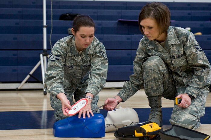 NELLIS AIR FORCE BASE, Nev.-- Staff Sgt. Stephanie Chastain, 99th Medical Group, life support program instructor, and Staff Sgt. Cheryl Hulsman, 57th Weapons School, public access defibrillation program coordinator, demonstrates how to use an Automated External Defibrillator April 7. The rodeo is a 30 min. class held at the Nellis fitness center, that teaches participants how to use an AED. The PAD program set up the AED rodeo so service members and civilians working on base become more aware of the equipments potential to save lives. (U.S. Air Force photo by Airman 1st Class Matthew Lancaster)
