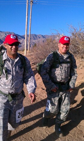 Master Sgt. Jayen Patel, 820th REDHORSE light production section chief, and Tech. Sgt. Tetsuo Douglas, 820th REDHORSE vehicle maintenance craftsman, are all smiles as they cross the four mile point of the marathon-distance Bataan Memorial Death March, March 27, at White Sands Missile Range.  The event, attended by a record number of more than 6,000 marchers, commemorates the original Bataan Death March which occurred in the Philippines during World War II. (Courtesy photo)