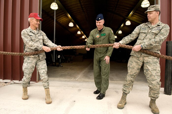 NELLIS AIR FORCE BASE, Nev.-- Lt. Col. Daniel Jefferies, 88th Test and Evaluation Squadron commander, cuts the ceremonial rope as Col. Darren Daniels, 820th Rapid Engineers Deployable Heavy Operational Repair Squadron Engineer commander, and Col. Steve Garland, 99th Air Base Wing commander, hold the rope during the grand opening of the squadron's new facility Mar. 17, here.  The newly constructed offices and warehouse will be the home of 88th TES.  The squadron is tasked to test and evaluate recovery operations equipment in support of the combat search and rescue and survival, evasion, resistance and escape career fields.  (U.S. Air Force photo by Airman 1st Class Daniel Hughes)