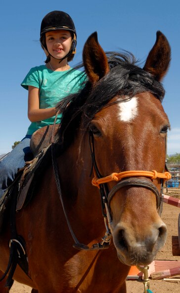 Madison, 7, daughter of Staff Sgt. David Lunsford, 56th Security Forces Squadron, sits on a horse and waits for further instructions April 3 during the Hearts Apart event at Sunset Ranch in Buckeye, Ariz.. The children were divided into three teams, which took turns participating in crafts, grooming and riding the horses.  (U.S. Air Force photo/Senior Airman Darlene Seltmann)
