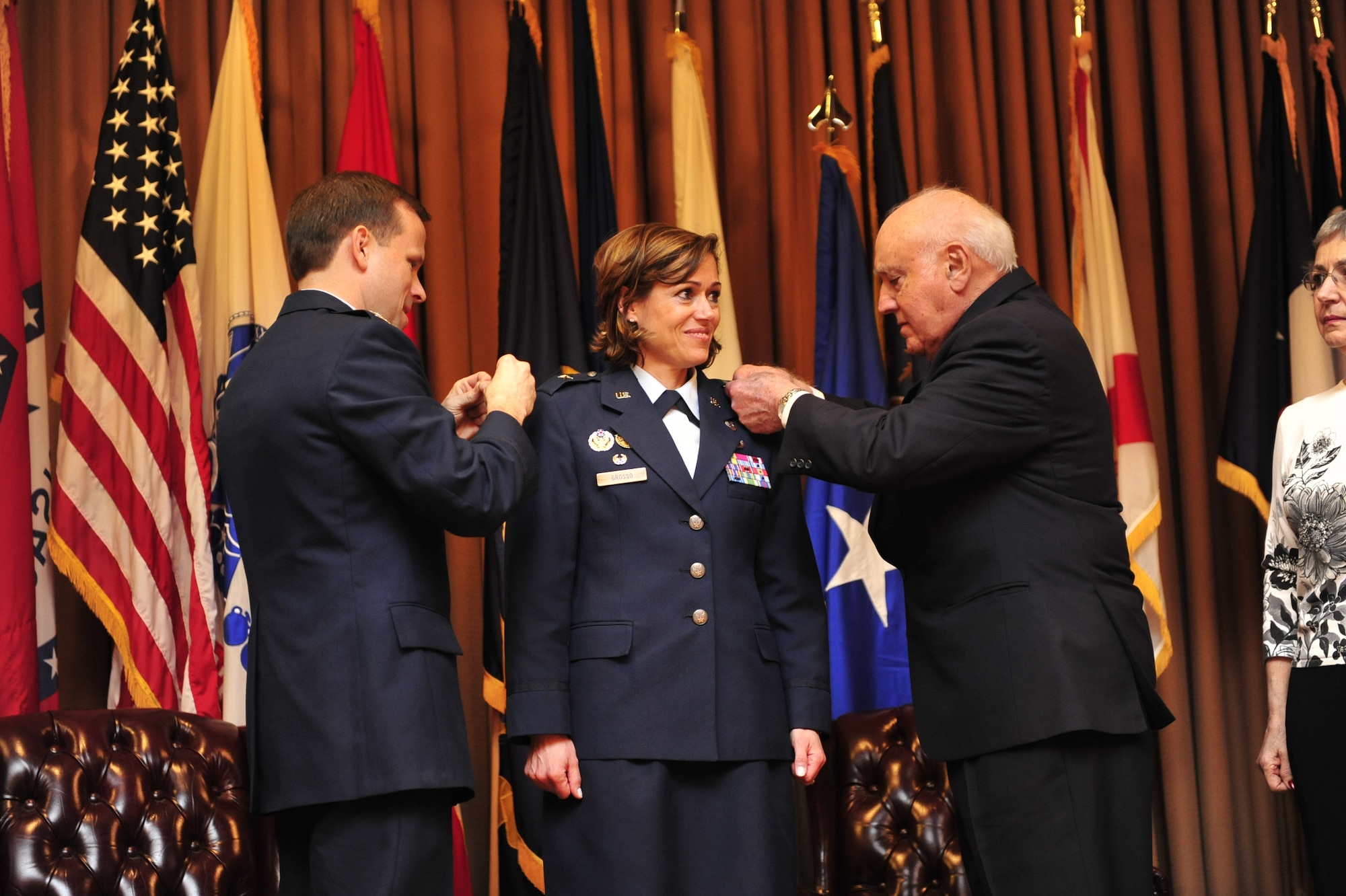 JOINT BASE MCGUIRE-DIX-LAKEHRUST, N.J. -- Brig. Gen. Gina Grosso waits for Col. Brian O’Connor and her father, retired Lt. Col. Gerald Grosso, to tack on her new rank during her promotion ceremony here April 8. Hundreds of community leaders and base leadership were on hand to witness the promotion of the joint base commander. (U.S. Air Force photo by Tech. Sgt. Parker Gyokeres/Released)