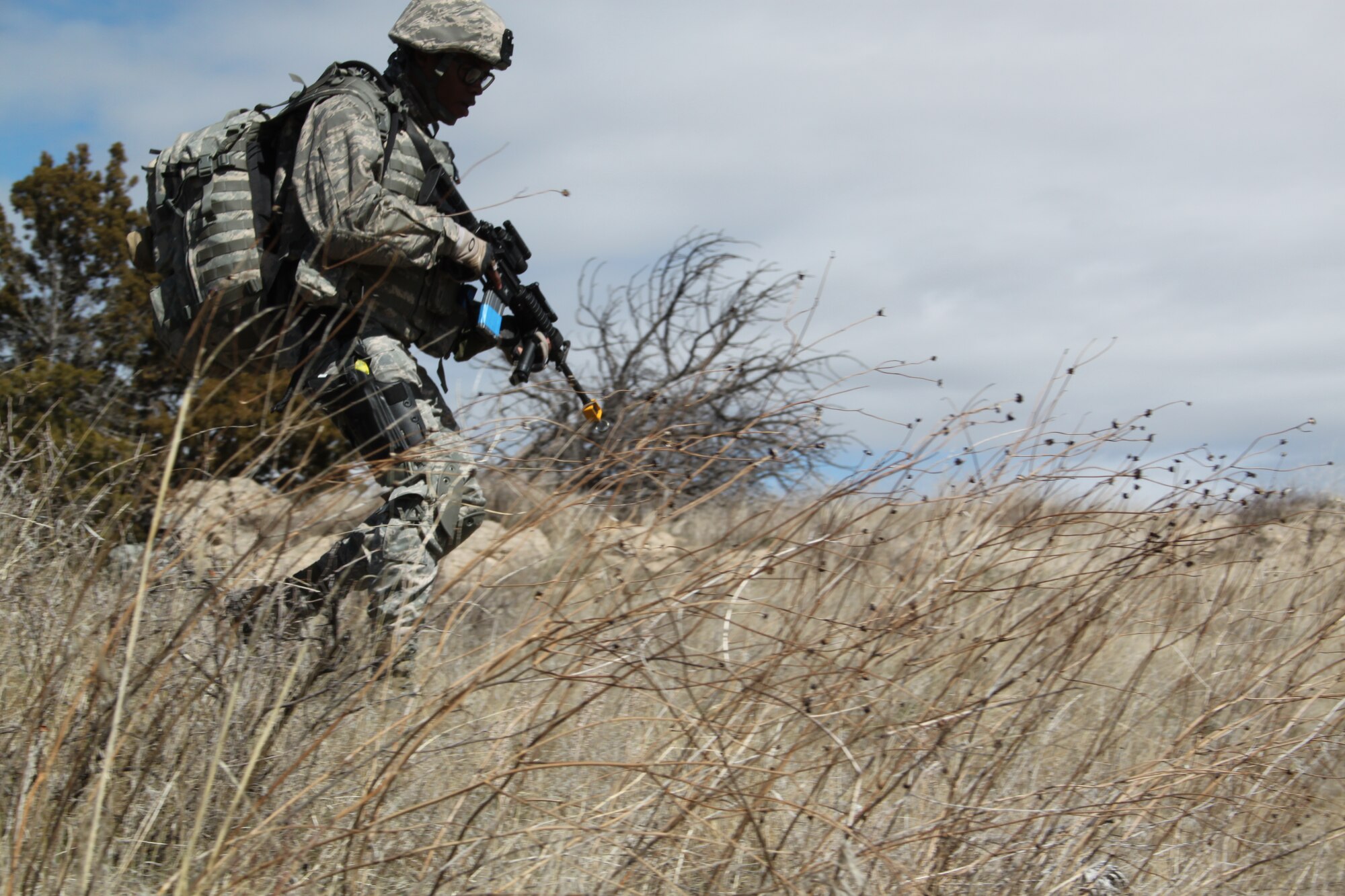Senior Airman Brian Bell, 710th Security Forces Squadron, hones his skills in land navigation on the high prairies of Camp Guernsey, Wyo. Airman Bell and his fellow security forces members hiked through challenging terrain following an hour and a half ride on a UH-60 “Blackhawk” helicopter April 1, during their inaugural field training exercise. (U.S. Air Force photo by Staff Sgt. Desiree Economides)