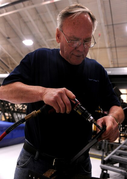 MOODY AIR FORCE BASE, Ga.-- Richard Bradshaw, contracted aircraft structural technician, removes burrs from a metal component during installation of a loadmaster crashworthy seat April 7. Aircraft engineers and technicians are currently engineering the first loadmaster crashworthy seat  in Air Combat Command to be trial tested in an HC-130P Combat King from the 71st Rescue Squadron.  (U.S. Air Force photo/Airman 1st Class Benjamin Wiseman)(RELEASED)