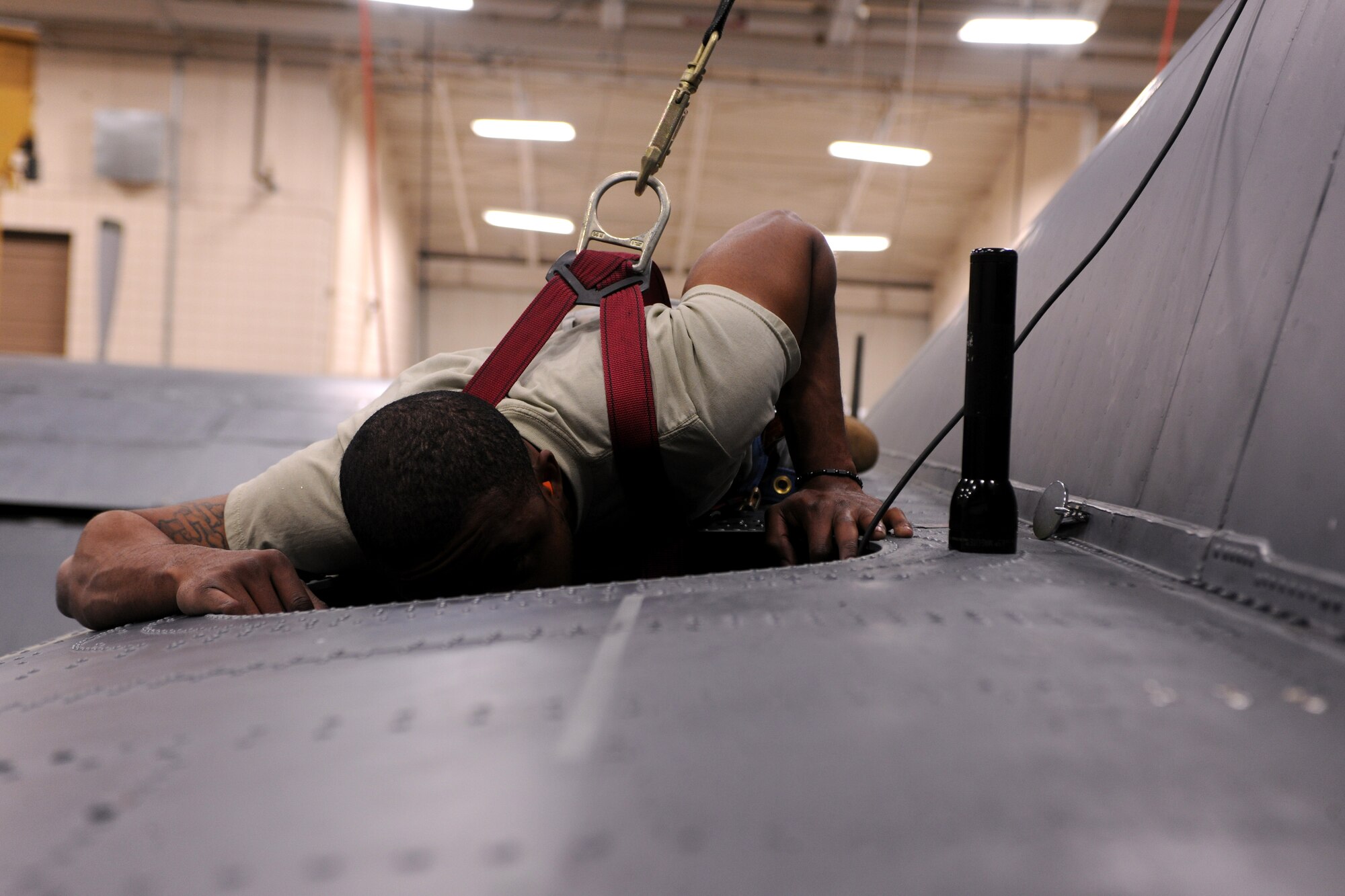 Staff Sgt. Ronald Golden, 23rd Equipment Maintenance Squadron sheet metal, looks through the HC-130P Combat King escape hatch during routine maintenance at Moody air Force Base, Ga., April 7. The aircraft was brought into a hangar and put on stands so members of the 23rd EMS could complete all the necessary repairs to the aircraft. (U.S. Air Force photo/Airman 1st Class Benjamin Wiseman)(RELEASED)