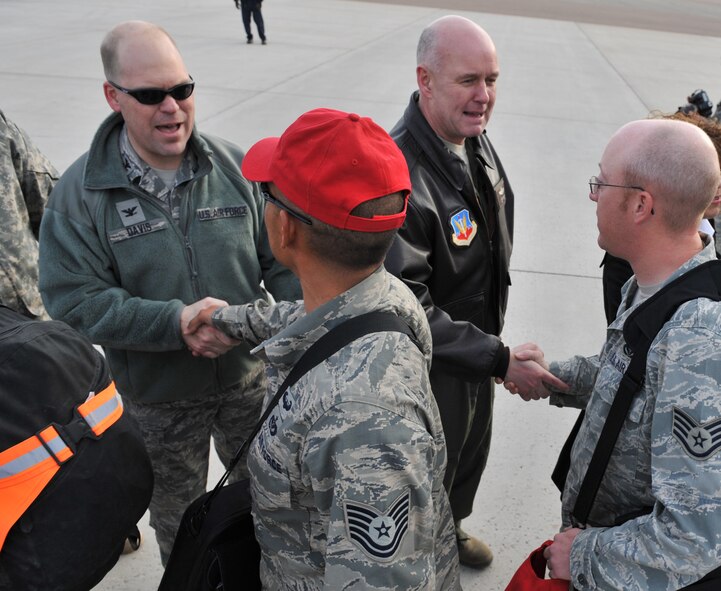 Col. Stephen Davis, 341st Missile Wing vice commander (left) and Col. Pete Hronek, 120th Fighter Wing commander, are part of a long line of well-wishers who welcomed home more than 300 members of the 819th and 219th RED HORSE Squadrons April 6. The military members were returning from a 6-month deployement to Southwest Asia. (U.S. Air Force photo/John Turner)