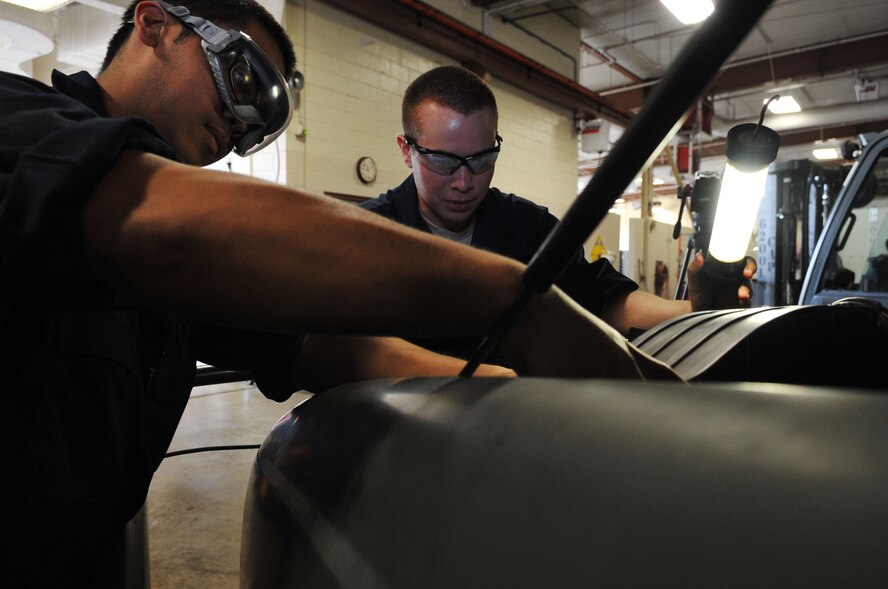 Airmen 1st Class Lloyd Bartolome and Justin Chapman, 2nd Logistics Readiness Squadron vehicle maintenance technicians, perform an overall inspection on a vehicle at Barksdale Air Force Base, La., April 7. An overall inspection consists of fluid, hose, corrosion and visual checks. The 2 LRS vehicle maintenance facility is responsible for more than 800 of Barksdale's government vehicles. (U.S. Air Force photo/Senior Airman Brittany Y. Bateman)(RELEASED)