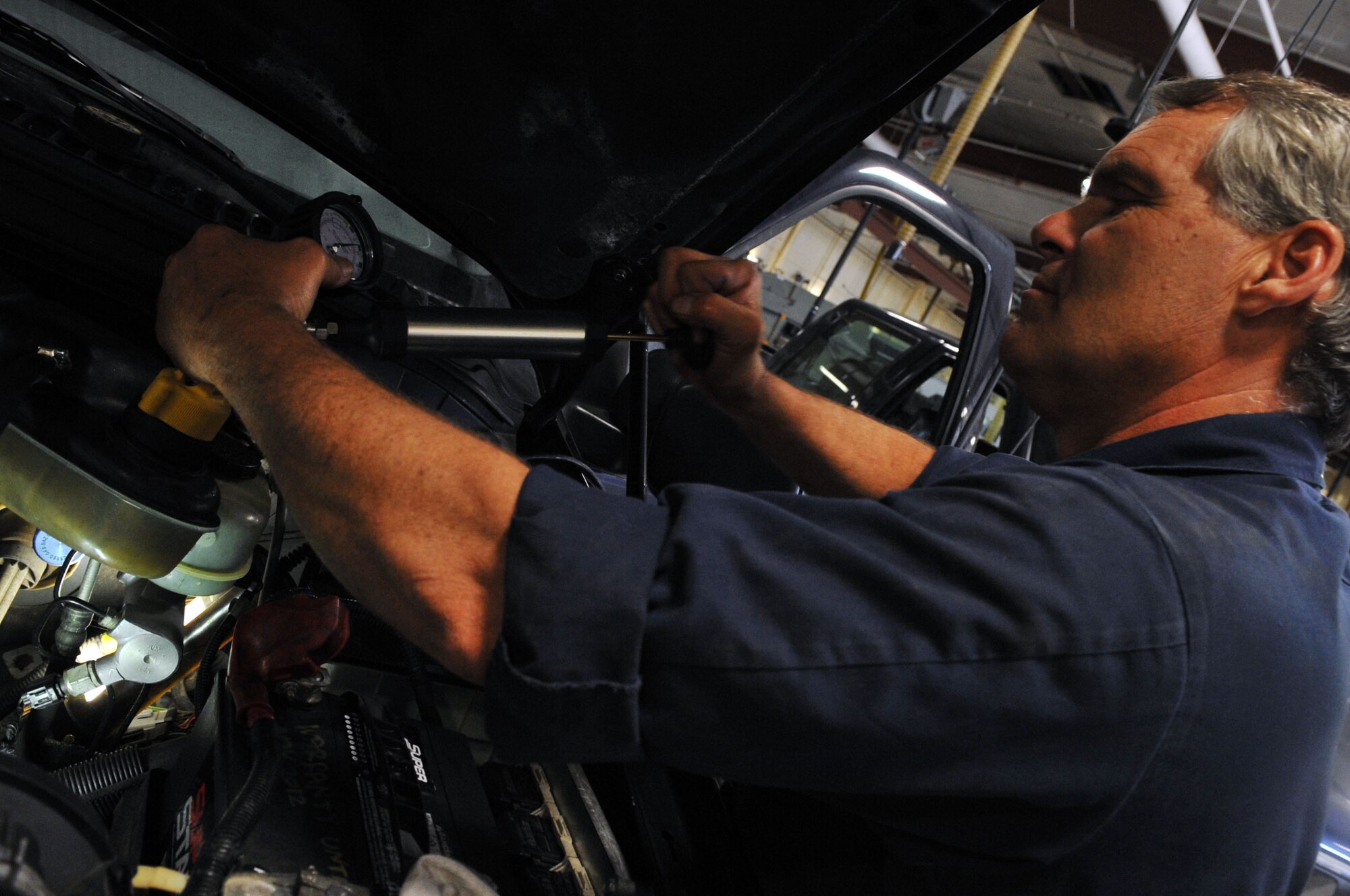 Kent Porter, 2nd Logistics Readiness Squadron vehicle maintenance technician, pumps air into a vehicle's cooling system to pressurize it, at Barksdale Air Force Base, La., April 7. The 2 LRS provides a variety of support across the base. Vehicle support consists of aircrew buses and a U-Drive-It fleet, as well as the maintenance of a $46 million vehicle fleet. (U.S. Air Force photo/Senior Airman Brittany Y. Bateman)(RELEASED)