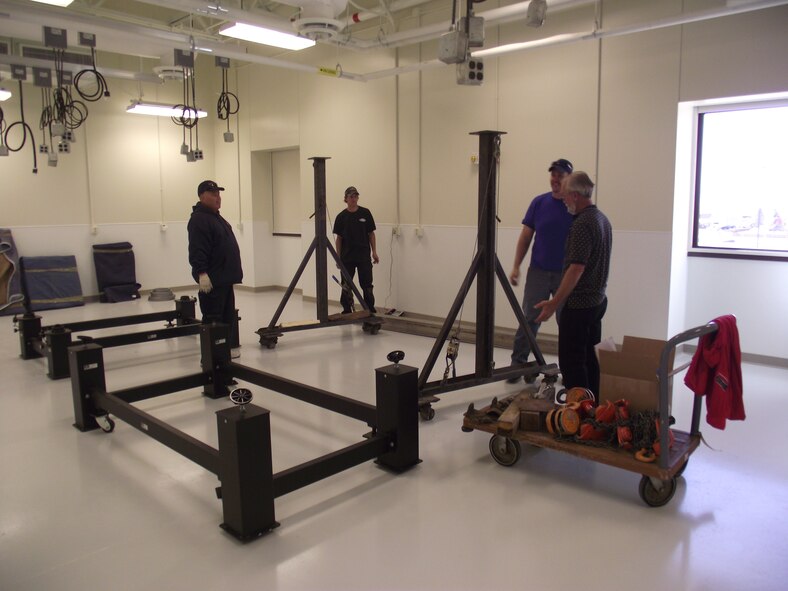A crew with Rockey’s Moving and Storage built a lifting device to lift an optical table weighing approximately 600 pounds and set it on the four-post platform.  U.S. Air Force Photo by Connie Rankin