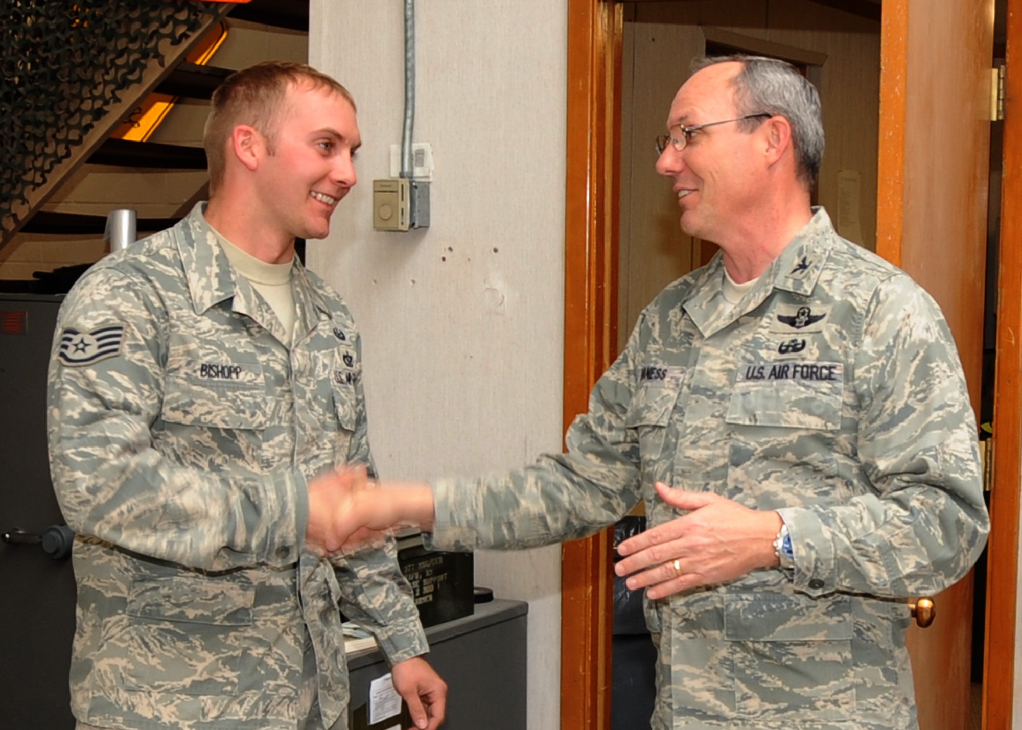 377th Air Base Wing commander, Col. Robert Maness, right, presents Staff Sgt. Jordan Bishopp with a coin in recognition of Bishopp’s NCO of the Year Award for AFMC.  U.S. Air Force Photo by Dennis Carlson