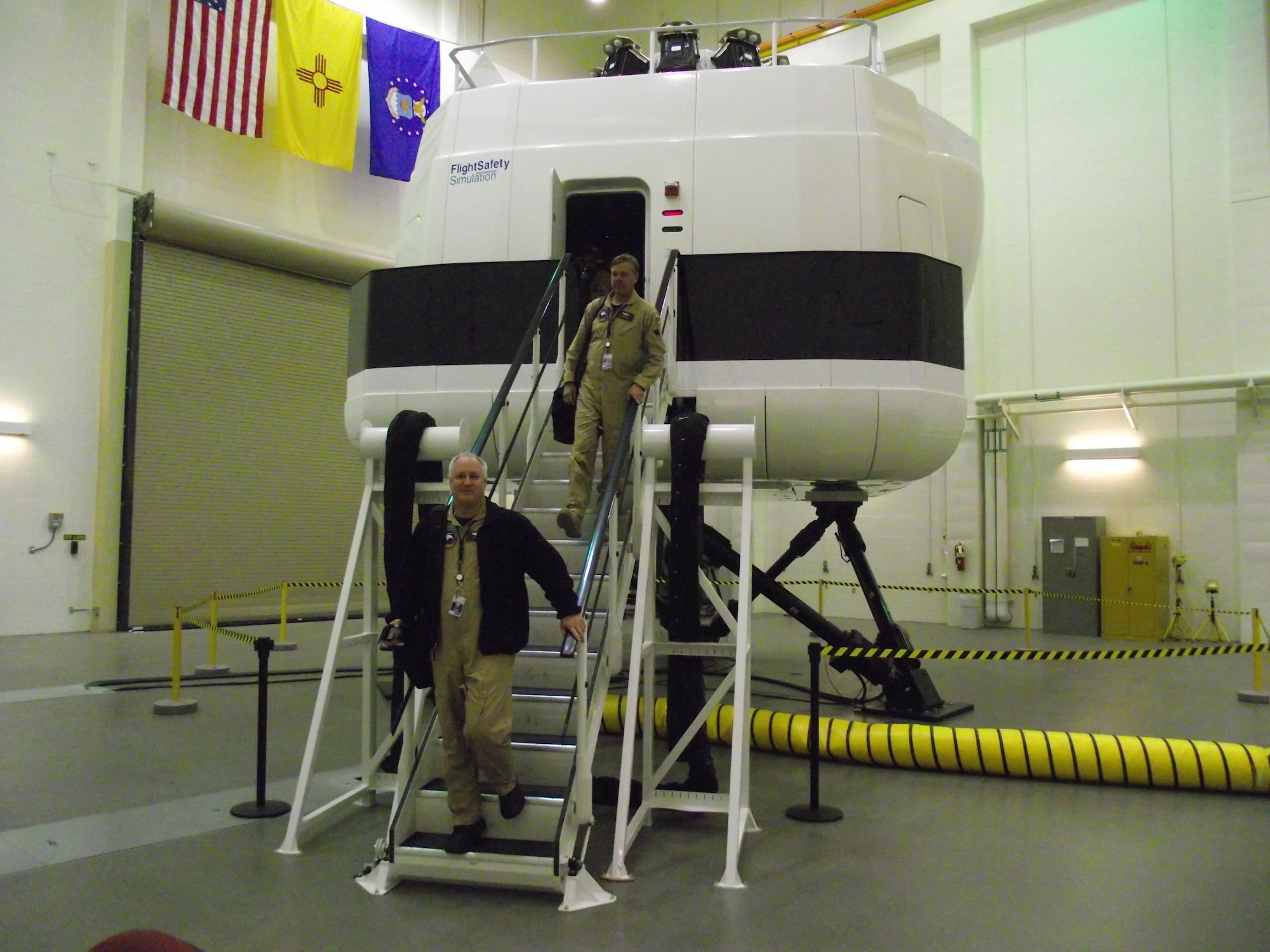 Robert Barnes, left, and Mike Kropski, Aircrew Training and Rehearsal Support instructors, exit the HC-130P simulator after a training exercise with aircrew students. U.S. Air Force Photo by Stefan Bocchino